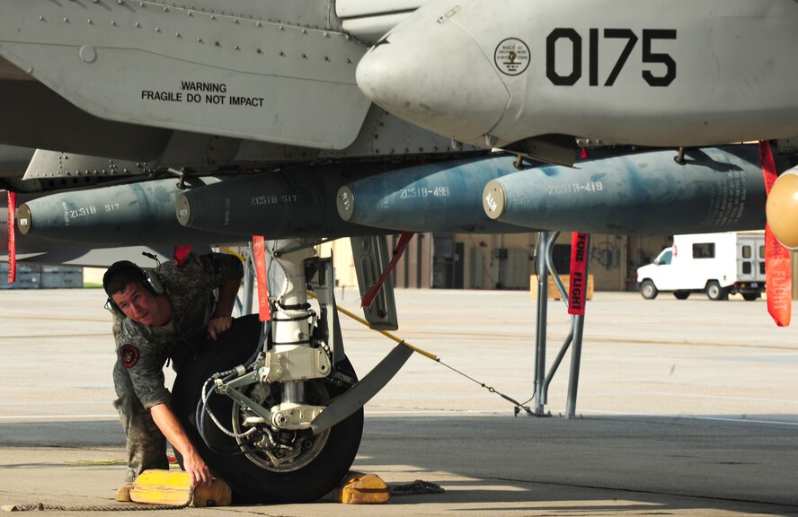 U.S. Air Force Staff Sgt. Kevin Donovan, 23rd Aircraft Maintenance Squadron crew chief, removes chocks from the wheels of an A-10C Thunderbolt II prior to a flight at Moody Air Force Base, Ga., Aug. 3, 2011. Crew chiefs maintain and repair aircraft and aircraft equipment, inspect and perform various functional checks and ensure aircraft are in optimal condition after flight. (U.S. Air Force photo by Senior Airman Stephanie Mancha/Released)