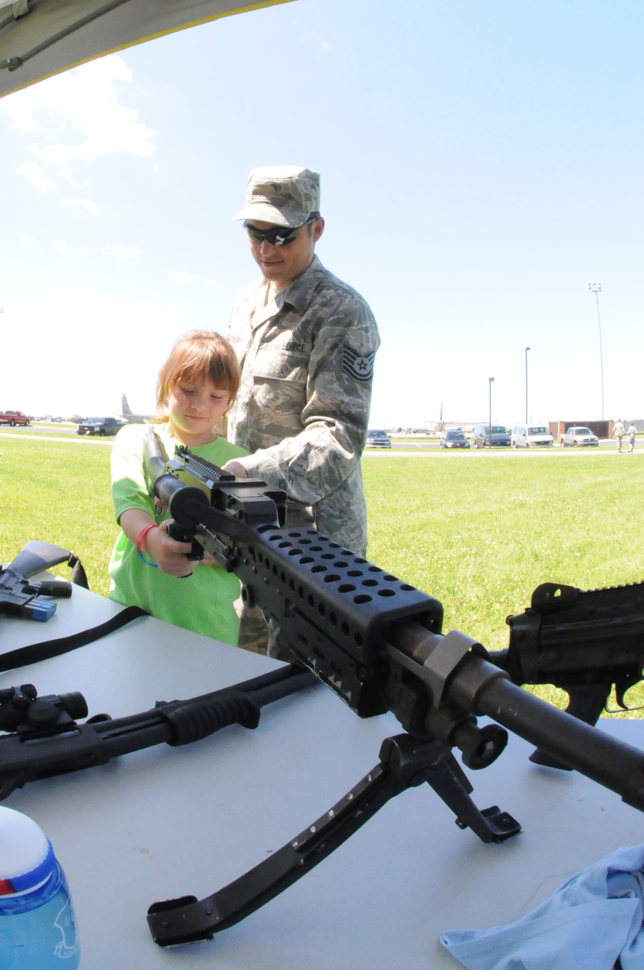 Marissa Shubert and her father, Tech. Sgt. Scott Shubert, get hands-on time with a M240B machine gun used by the U.S. Air Force Security Forces. Members of the 126th Air Refueling Wing, located at Scott AFB, Ill., brought their children to work for a "Kids on Guard" day that lets children experience duties and training events that Illinois Air National Guard personnel go through on a regular basis. (U.S. Air Force photo by Master Sgt. Ken Stephens.)