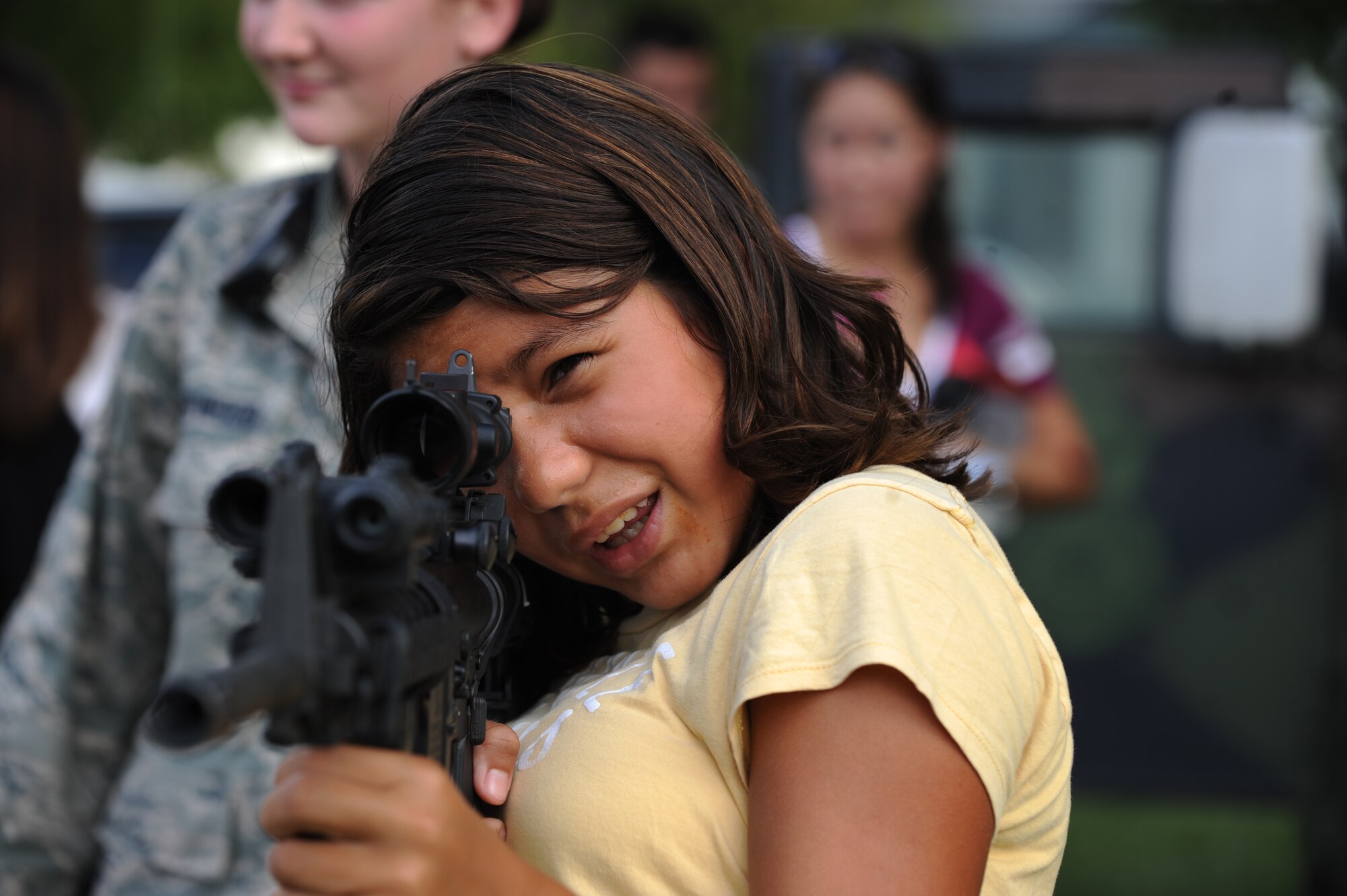Adriana Sanchez, 13, looks through an Advanced Combat Optical Gunsight mounted onto an M-4 carbine during the fourth annual National Night Out on Barksdale Air Force Base, La., Aug. 2. The 2nd Security Forces Squadron brought out three M-4 carbines, an M-24 sniper rifle and an M-249 light machine gun. All weapons on display had the bolt and the bolt carrier group removed to prevent them from firing. (U.S. Air Force photo/Airman 1st Class Micaiah Anthony)(RELEASED)