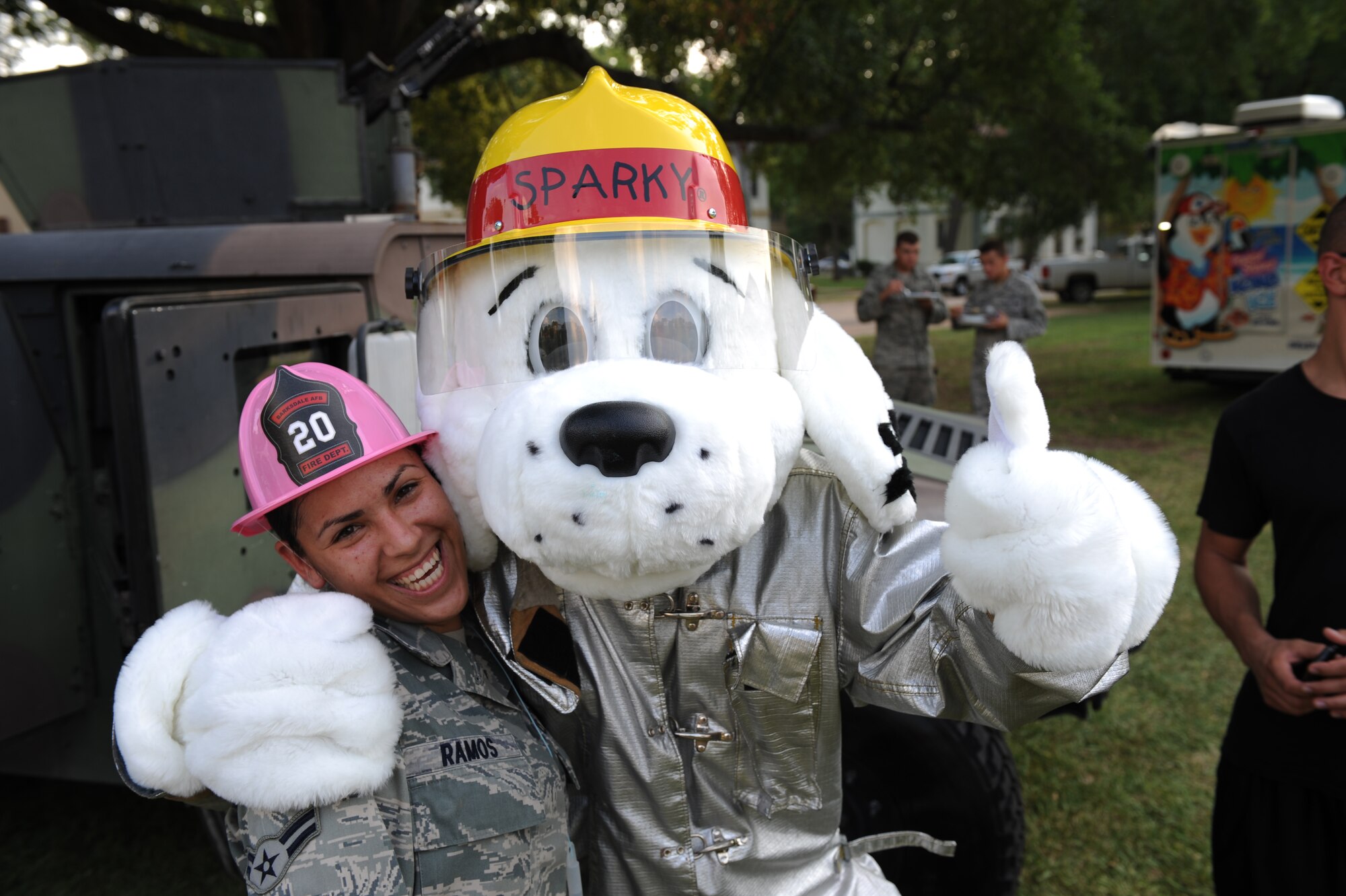 Airman 1st Class Jesusa Ramos, 2nd Security Forces Squadron, poses with Sparky the fire dog during the fourth annual National Night Out on Barksdale Air Force Base, La., Aug. 2. Participants of the event were able to meet and take photos with McGruff the crime dog and Sparky the fire dog. (U.S. Air Force photo/Airman 1st Class Micaiah Anthony)(RELEASED)