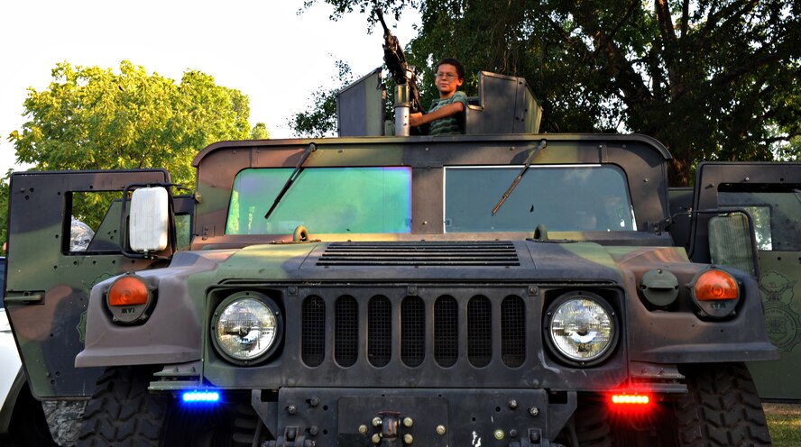 Devin Thrower, 10, stands behind an M-240 machine gun mounted to a HUMVEE during the fourth annual National Night Out on Barksdale Air Force Base, La., Aug. 2. The 2nd Security Forces Squadron displayed weapons, a patrol car and a HUMVEE to give participants a closer look at the equipment and vehicles they use. (U.S. Air Force photo/Airman 1st Class Micaiah Anthony)(RELEASED)