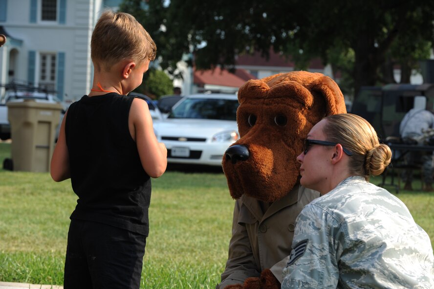 Bryan Henderson, 7, talks with McGruff the crime dog and Staff Sgt. Hannah Vega, 2nd Security Forces Squadron, during the fourth annual National Night Out on Barksdale Air Force Base, La., Aug. 2. Participants of the event were able to meet and take photos with McGruff the crime dog and Sparky the fire dog. (U.S. Air Force photo/Airman 1st Class Micaiah Anthony)(RELEASED)