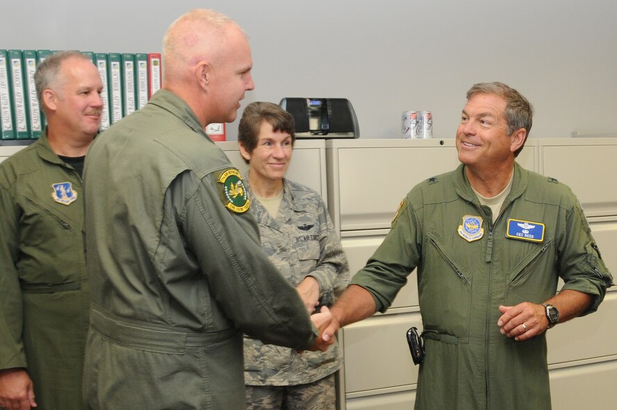 Brig. Gen. Harold E. Reed, assistant to the commander of the 18th Air Force, presents a coin to Tech. Sgt. Steven Stanton, chief boom scheduler for the 77th Air Refueling Squadron here, for exceptional work performance during an official tour of the 916th Air Refueling Wing's operations facilities here Aug. 2, 2011.  Reed also gave coins to Master Sgt. Robert Fox, Master Sgt. Catherine Harris, Tech. Sgt. Scott Walther and Staff Sgt. Keith Winters. (USAF photo by Senior Airman Meredith A. H. Thomas, 916 ARW/PA)