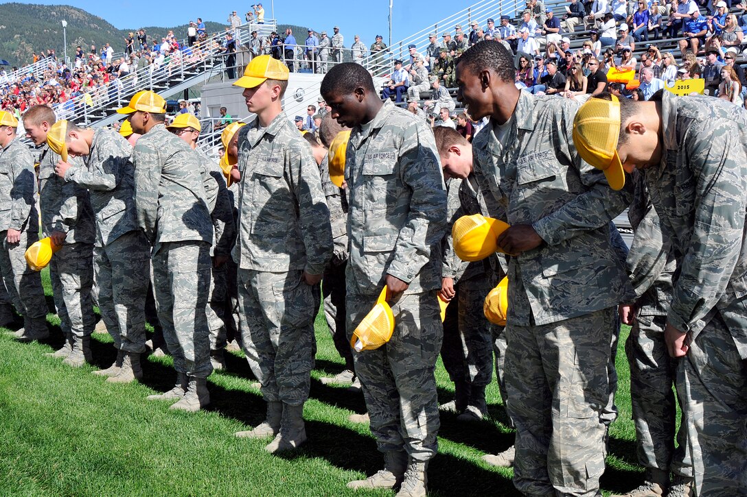 Cadets in the Class of 2015 exchange their baseball caps for Airman Battle Uniform caps to signify their transition into the Cadet Wing during the Acceptance Day Parade Aug. 3, 2011. The baseball caps are gold, signifying the freshmen's class color. (U.S. Air Force photo/Megan Davis)