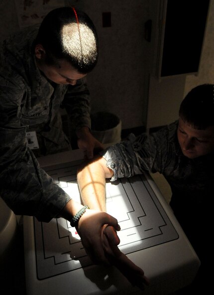 Senior Airman Sean McCarty, 2nd Medical Support Squadron technician, arranges a patients arm before an x-ray at the Barksdale Air Force Base clinic Aug. 2. The Air Force diagnostic imaging technologists, or radiologist technicians, attend a 52-week technical training program to learn about the entire anatomy of the body, including the electronic circuitry, cardiopulmonary system, digestive track, reproductive organs, the brain and circulatory system. They also perform computed tomography scans and digital radiology. (U.S. Air Force photo/Senior Airman Amber Ashcraft) (RELEASED)