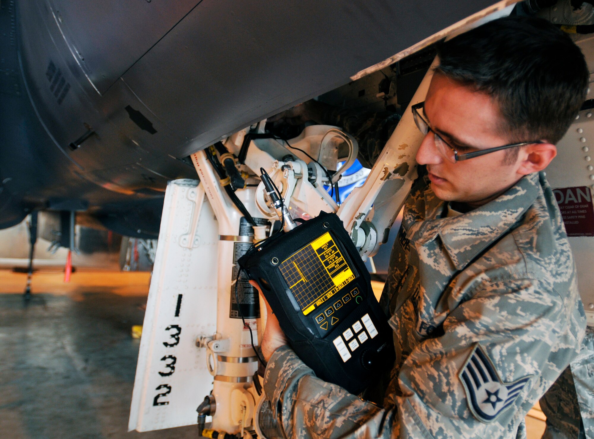 ROYAL AIR FORCE LAKENHEATH, England - Staff Sgt. Michael Sommer, 48th Equipment Maintenance Squadron Nondestructive Inspection journeyman, uses a Nortec 2000D+ eddy current flaw detector to inspect an aircraft?s landing gear well for cracks at RAF Lakenheath, Aug. 2, 2011. Airmen from the NDI are responsible for finding the smallest aircraft defects so they can be repaired to prevent larger problems. (U.S. Air Force photo/Senior Airman Tiffany M. Deuel)