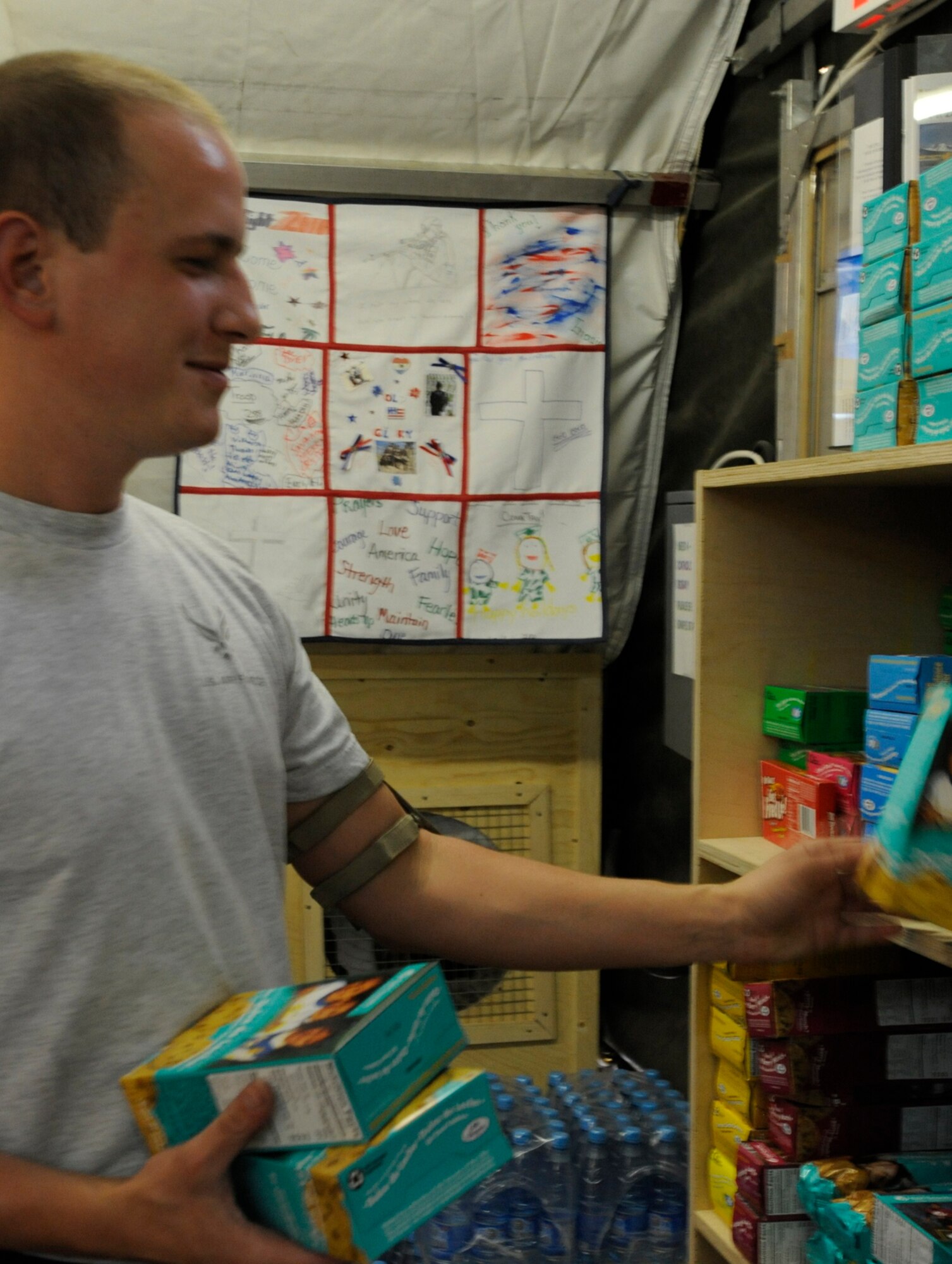 Senior Airman Kyle Eisenbarth stocks shelves as the Transit Center chapel Aug. 3. The chapel office tent, located directly behind the chapel, serves as an area for people to relax, grab a few supplies, enjoy a snack, socialize with others, fellowship or seek counseling. Eisenbarth is a chapel volunteer and 376th Expeditionary Logistics Readiness Squadron Expeditionary Theater Distribution Center journeyman. He is deployed here from Cannon Air Force Base, N.M. (U.S. Air Force photo/Tech. Sgt. Tammie Moore)