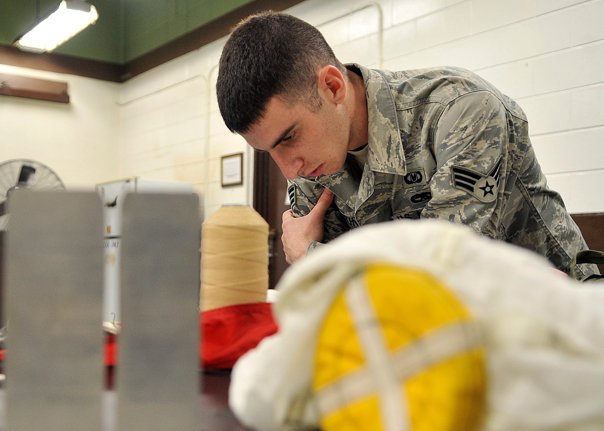 Senior Airman Ryan Smith, 51st Operation Support Squadron air crew flight equipment journeymen, reads pages from his tactical order during the reassembling of a Republic of Korea’s F-4 fighter plane. The tactical order is a step-by-step book of data that is used with every repack of a   Republic of Korea’s F-4 fighter plane. .  (U.S. Air Force Photos by/ Senior Airman Adam Grant)