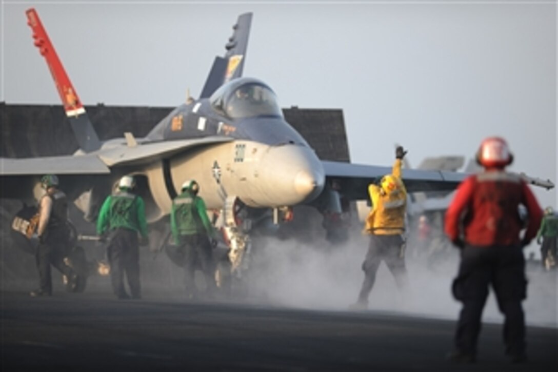 U.S. Navy sailors prepare to launch an F/A-18C Hornet aircraft assigned to Strike Fighter Squadron 15 aboard the aircraft carrier USS George H.W. Bush (CVN 77) in the Arabian Sea on Aug. 2, 2011.  The George H.W. Bush is deployed to the U.S. 5th Fleet area of responsibility on its first operational deployment conducting maritime security operations and support missions as part of Operations Enduring Freedom and New Dawn.  
