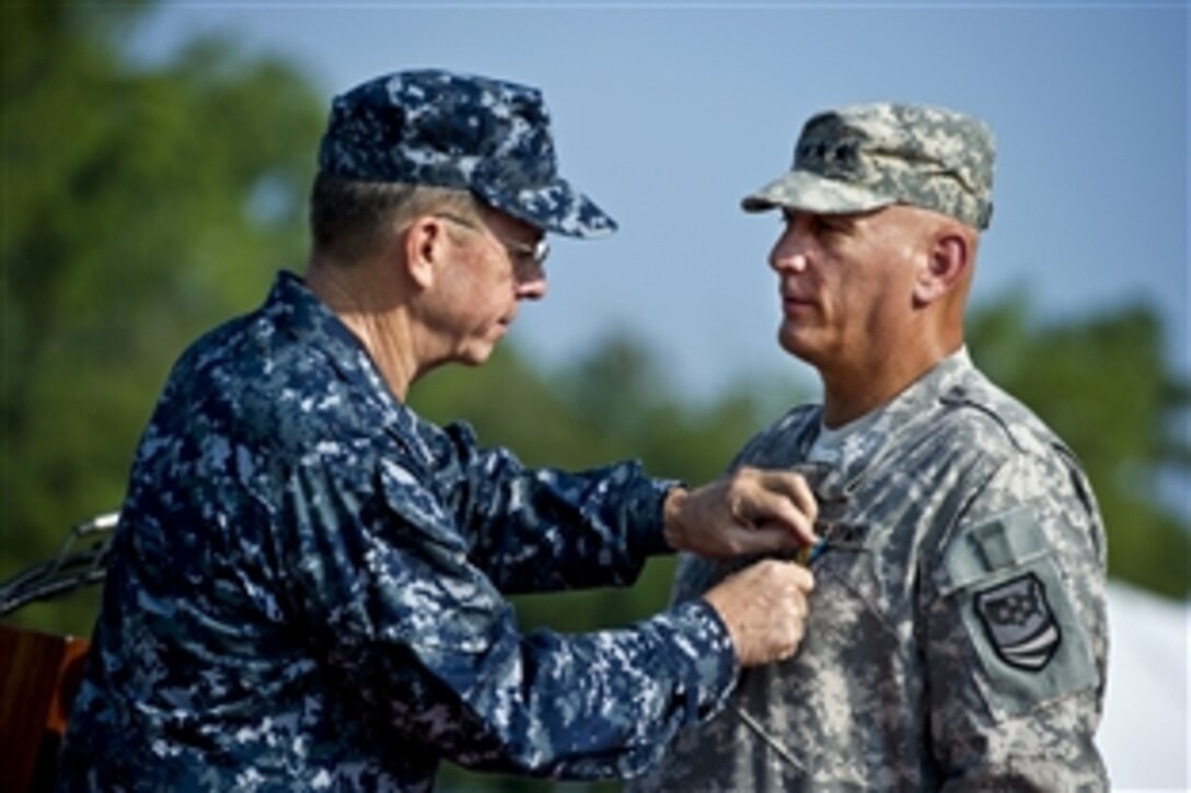 Navy Adm. Mike Mullen, chairman of the Joint Chiefs of Staff, presents Army Gen. Raymond T. Odierno, commander of U.S. Joint Forces Command, with the Defense Distinguished Service Medal at the command's disestablishment ceremony in Suffolk, Va., Aug. 4, 2011.