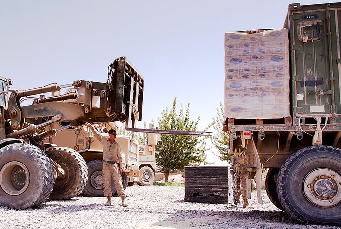 Lance Cpl. Jonathan Drake directs a tram to unload pallets of water at Combat Outpost Gorgak, Aug. 4. Drake, a native of Klamath Falls, Ore., is a gunner and driver with 3rd Trucks Platoon. Originating from Marine Corps Bases Japan, 3rd Trucks Platoon is attached to 1st Battalion, 3rd Marine Regiment. Trucks Platoon is responsible for logistical deliveries throughout 1/3’s area of operations.