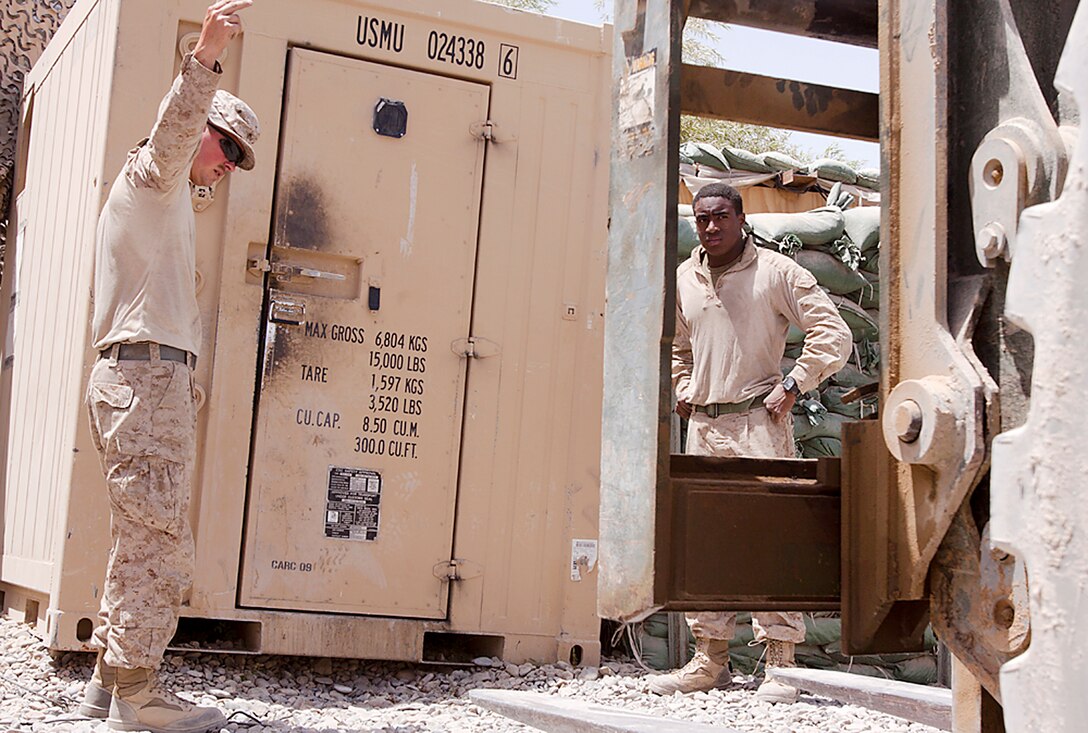 Staff Sgt. Travis Bartels and Lance Cpl. Ryan Shephard direct a tram to lift a giant freezer at Patrol Base May, Aug. 4. Bartels, a native of Mattoon, Ill., is the platoon sergeant for 3rd Trucks Platoon. Shephard, a native of Olathe, Kan, is a driver and gunner for 3rd Trucks Platoon. Originating from Marine Corps Bases Japan, 3rd Trucks Platoon is attached to 1st Battalion, 3rd Marine Regiment. Trucks Platoon is responsible for logistical deliveries throughout 1/3’s area of operations.