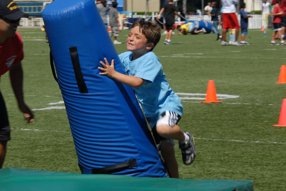Cameron Reyes, 7, attacks one of the pads on the San Diego Chargers Junior Training Camp August 4. Cameron and 23 other military children came out to the camp with Marine Corps Community Services. MCCS has been bringing children out four years.