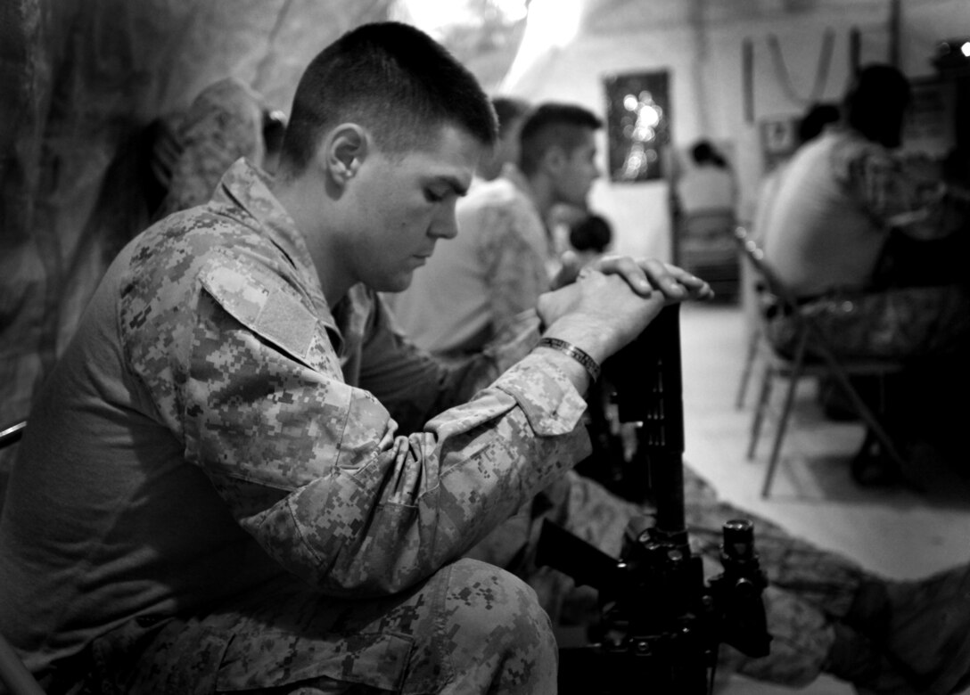 Cpl. Timothy Stark, a mortarman, from Westerlo, N.Y., with Headquarters and Service Company, 1st Battalion, 6th Marine Regiment, waits in line to use the morale phones to call his pregnant wife back in the states, Aug. 4, 2011. Stark, who is on his third deployment to Afghanistan with 1/6, will be deployed when his daughter is born.