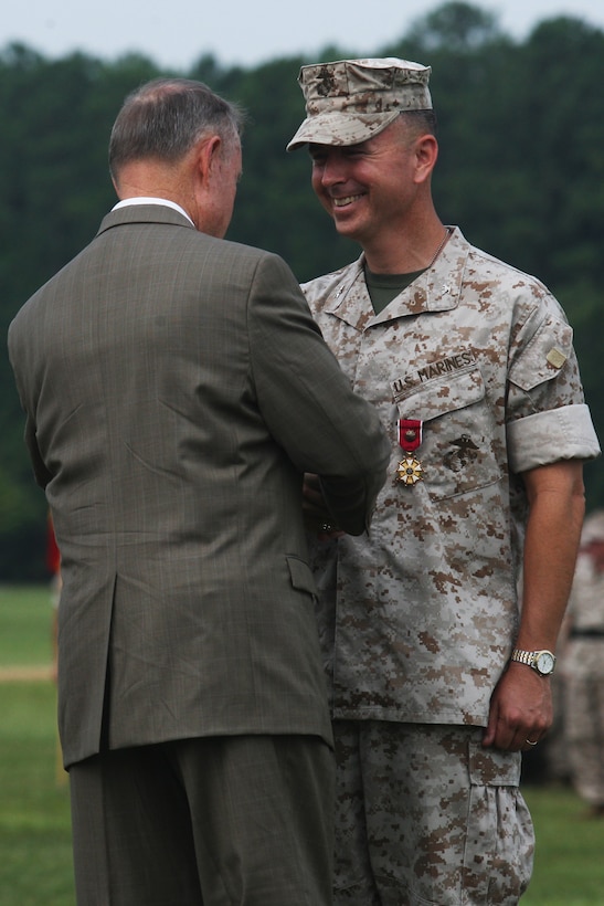 Col. Timothy S. Mundy (right), outgoing commanding officer of School of Infantry - East, receives the Legion of Merit from his father, retired Gen. Carl E. Mundy, 30th commandant of the Marine Corps, during the SOI-EAST change of command ceremony aboard Camp Geiger, Aug. 5. Fitzpatrick is coming into command following a year-long deployment with I Marine Expeditionary Force (Forward) while Mundy is assigned to 2nd Marine Division.