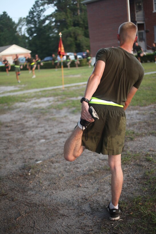 Pfc. Ian Dangler, intelligence analyst with the 26th Marine Expeditionary Unit, performs a cool down stretch led by Sgt. Maj. Todd M. Parisi, 26th MEU sergeant major, after a unit physical training session at Camp Lejeune, N.C., Aug. 5, 2011. The event included a four mile run, and brought together all members of the MEU Command Element in a showing of physical strength, endurance and esprit de corps. (U.S. Marine Corps photo by Cpl. Christopher Q. Stone)