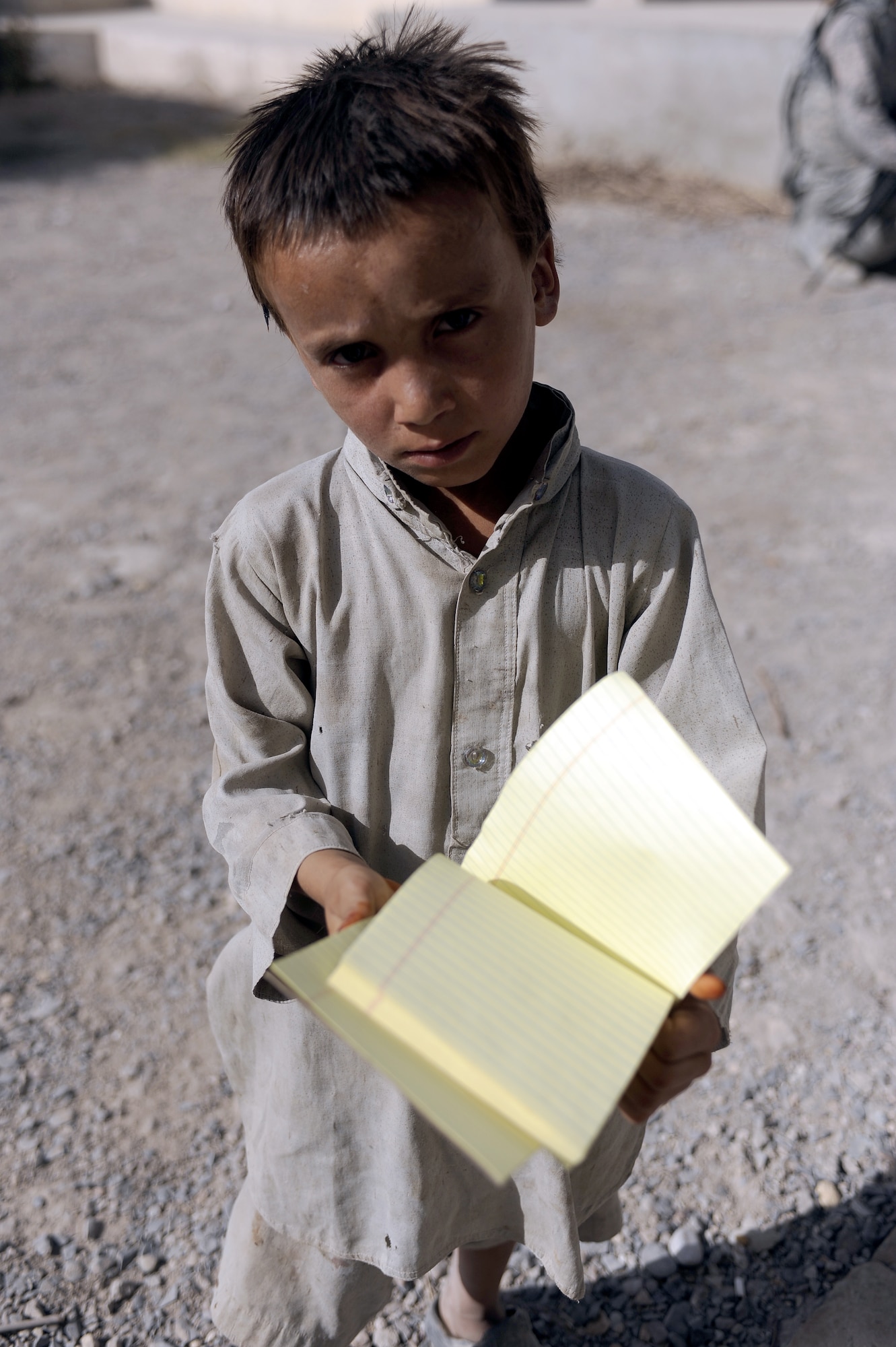 An Afghan child shows off his new notepad July 2nd, 2011, in Kandahar Province, Afghanistan. School supplies were being handed out as part of a humanitarian aid mission being conducted by the Air Force Office of Special Investigations.  (U.S. Air Force photo by Senior Airman Willard E. Grande II)