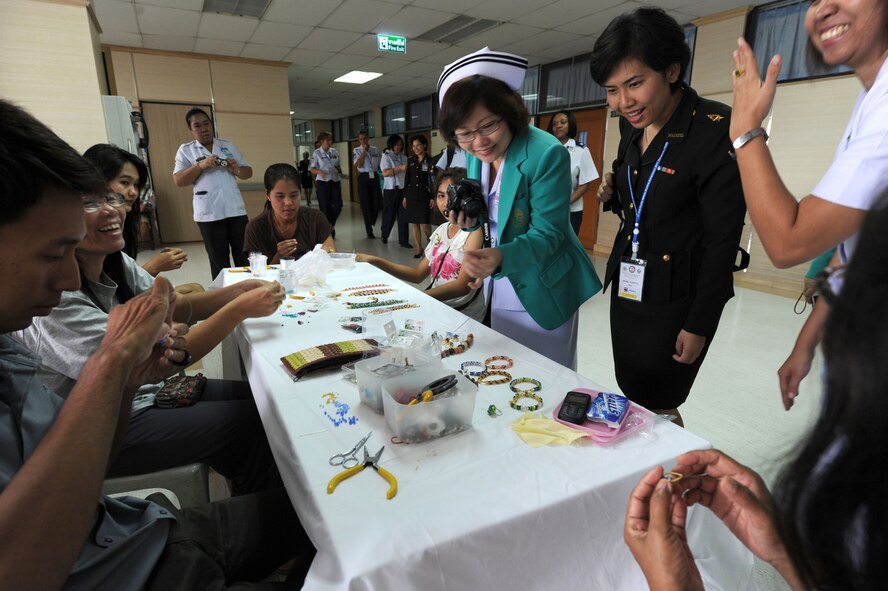 BANGKOK, Thailand - Members of the military nursing community in the Pacific region watched as family members of a patient at Phramongkutklao Hospital in Bangkok, Thailand make jewelry that will be used to raise money that will offset future hospital care. The nursing community toured the prestigious hospital on Aug. 3 as part of the 2011 Asia Pacific Military Nursing Symposium, which is sponsored by Pacific Command and executed under the direction of 13th Air Force.
This is the fifth year of the symposium, which started at Hickam Air force Base in 2007, and the first time that Thailand has hosted the event.
More than 12 countries from the Asia-Pacific region have come together to build on relationships by exchanging information and techniques with one another. (U.S.  Air Force photo/Master Sgt. Cohen A. Young)
