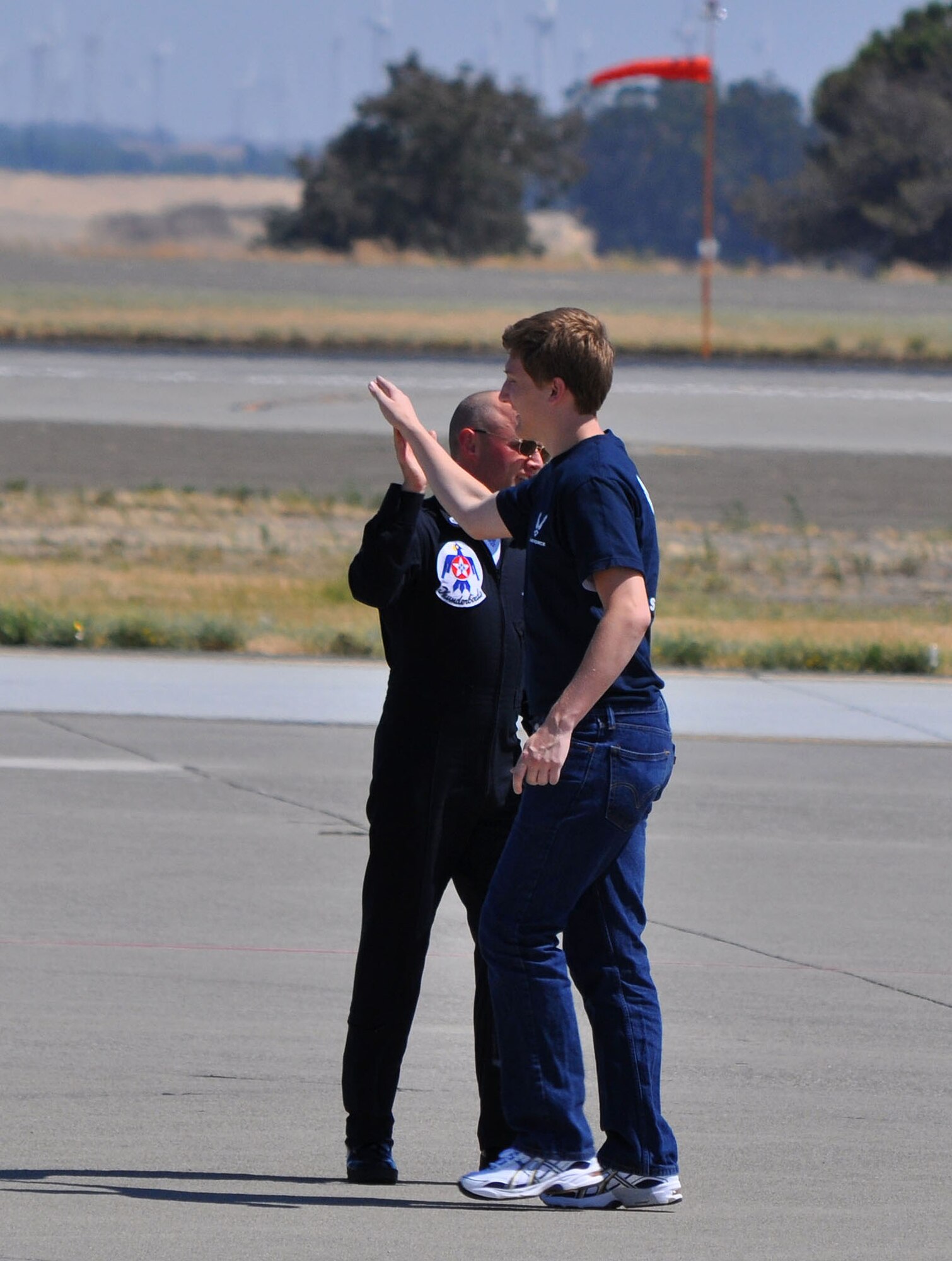 TRAVIS AIR FORCE BASE, Calif. -- One of the elite maintenance team of the U.S. Air Force Thunderbirds "high fives" a new Air Force enlistee July 30. More than 60 young men and women stood as a group on the Travis AFB flight line, during the 2011 Air Power Expo, and were sworn into the Air Force. For those choosing the Reserve, Travis is one of five pilot bases launching a Delayed Enlistment Development and Training Flight. While awaiting a report date to basic military training, enlistees will report to the 349th Air Mobility Wing Flight Leader, Master Sgt. Heather Bradley, for training that will help them make the transition from civilian to Airman. Wearing blue Air Force Reserve tee shirts and blue jeans, they will report on Saturdays of A and B Flight UTA at 7:20 a.m., to the Airman Leadership School. Their curriculum will include uniform standards and inspections, drill and ceremony, Air Force heritage, physical training and more. Right now, there are about 80 enlistees in the program. Volunteers are sought to assist with the training and mentoring. Please contact Sergeant Bradley at 424-1693, or email her at heather.bradley@us.af.mil. (U.S. Air Force photo/Senior Master Sgt. Ellen L. Hatfield)
