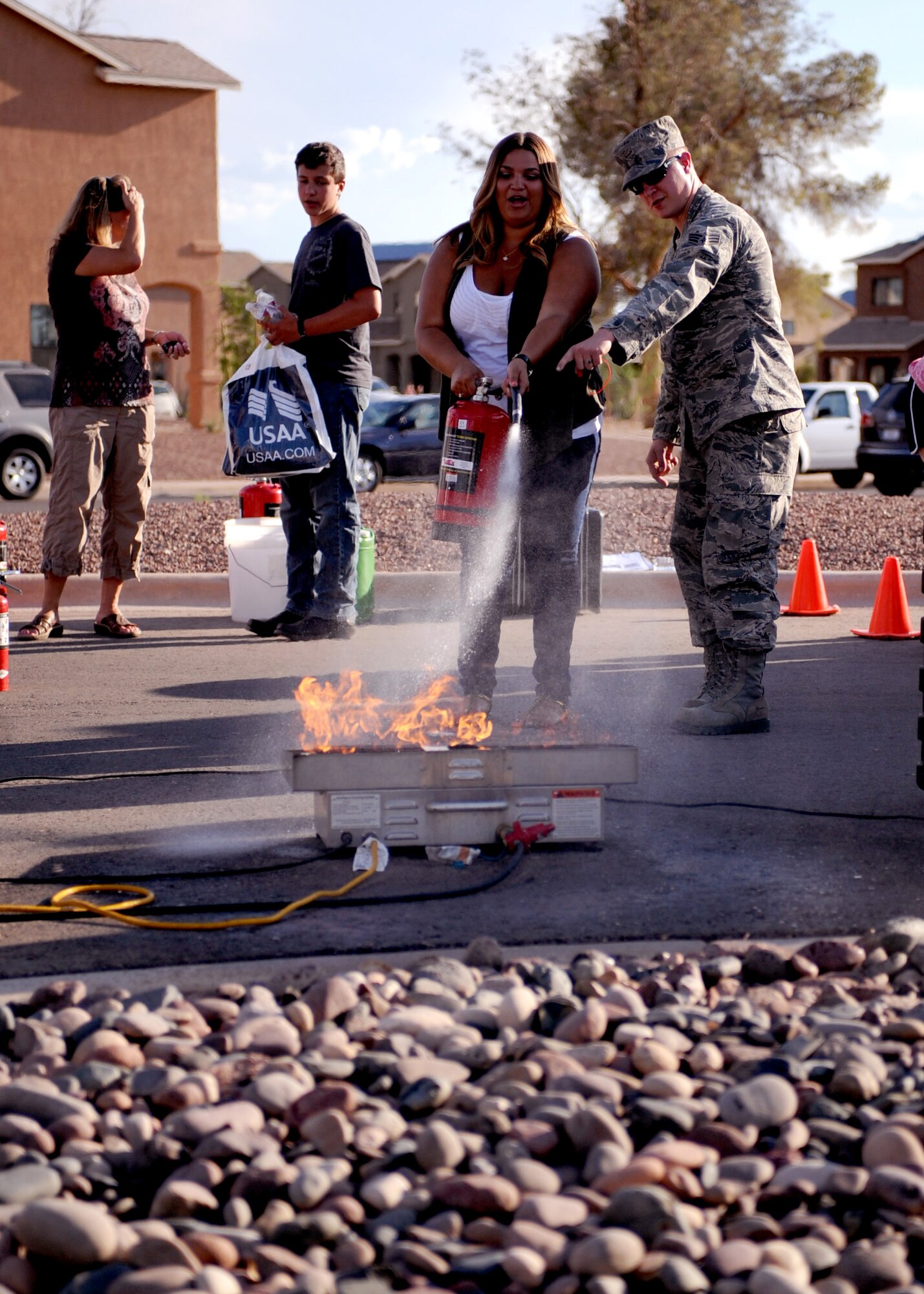 DAVIS-MONTHAN AIR FORCE BASE, Ariz. -- Senior Airman Richard Lecznar, from the 355th Civil Engineer Squadron, demonstrates how to use a fire extinguisher at the National Night Out event here Aug. 2. Soaring Heights Community hosted National Night Out to promote neighborhood and police-community partnership. (U.S. Air Force photo/Airman 1st Class Christine Halan)
