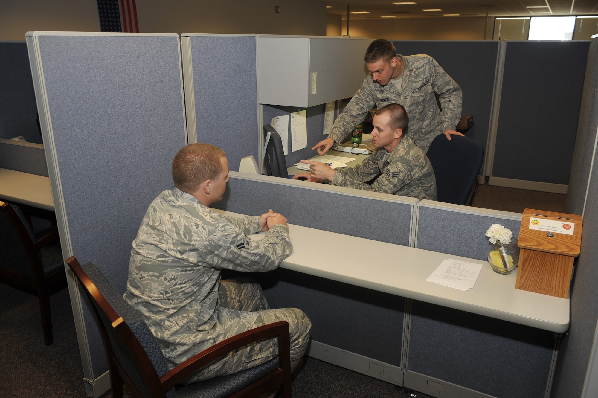 2nd Lt. Christopher Silver and Senior Airman Ryan Sison, both from the 21st Comptroller Squadron, assist an Airman with military pay questions.  On Aug. 25, military pay processing returns to the 21st CPTS and other Air Force bases’ finance offices. This means that finance will locally process documents directly impacting individuals’ military pay records.  (U.S. Air Force photo/Rob Lingley)
