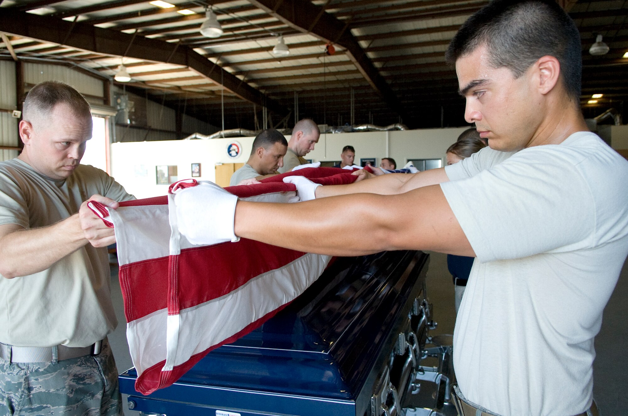 PATRICK AIR FORCE BASE, Fla. -- Patrick Honor Guard members practice folding a flag for a funeral detail. HG is made up of volunteer members representing various Air Force units on Patrick AFB and Cape Canaveral AFS, who serve on one of three rotating flights, for one year minimum. Getting these Airmen trained and keeping them consistently sharp is a time-consuming, behind-the-scenes effort of HG Superintendent Master Sgt. Kevin Matthews and a team of professional full-time staff members, who augment, conduct day-to-day operations, training and assist with details. (U.S. Air Force photo by Julie Dayringer)