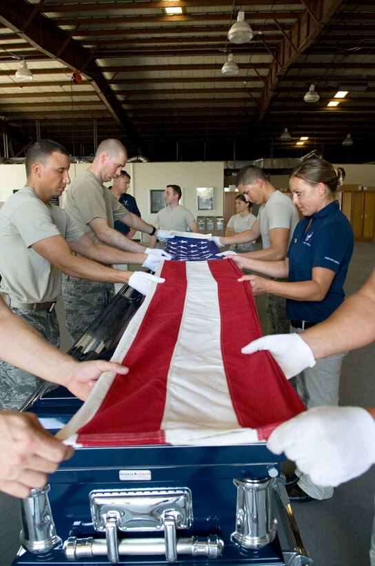PATRICK AIR FORCE BASE, Fla. -- Patrick Honor Guard members practice folding a flag for a funeral detail. HG is made up of volunteer members representing various Air Force units on Patrick AFB and Cape Canaveral AFS, who serve on one of three rotating flights, for one year minimum. Getting these Airmen trained and keeping them consistently sharp is a time-consuming, behind-the-scenes effort of HG Superintendent Master Sgt. Kevin Matthews and a team of professional full-time staff members, who augment, conduct day-to-day operations, training and assist with details. (U.S. Air Force photo by Julie Dayringer)