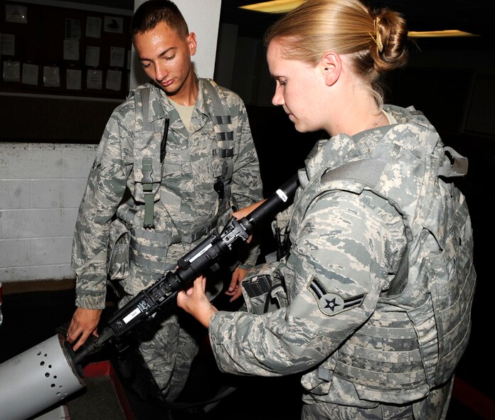Airman Nolan Petty, 2nd Security Forces Squadron patrolman, double checks to make sure Airman 1st Class Caitlin Dzirson, also of the 2nd SFS, has properly cleared her weapon prior to returning it to the armory on Barksdale Air Force Base, La., Aug. 5. Security forces Airmen check weapons and ammunition out of the armory each day before their shift and return the items at the end of their shift. The weapons must be properly cleared before being stored. (U.S. Air Force photo/Staff Sgt. Terri Barriere) (RELEASED)
