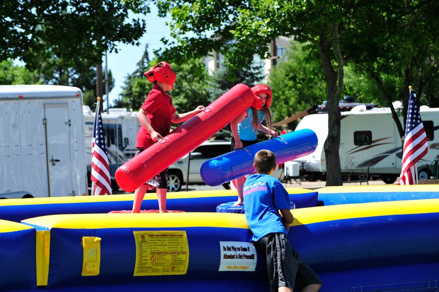Kids duke it out on one of the many inflatable playgrounds provided for the picnic. The area surrounding the park was filled with activities for families. (U.S. Air Force photo by Kim Cook)