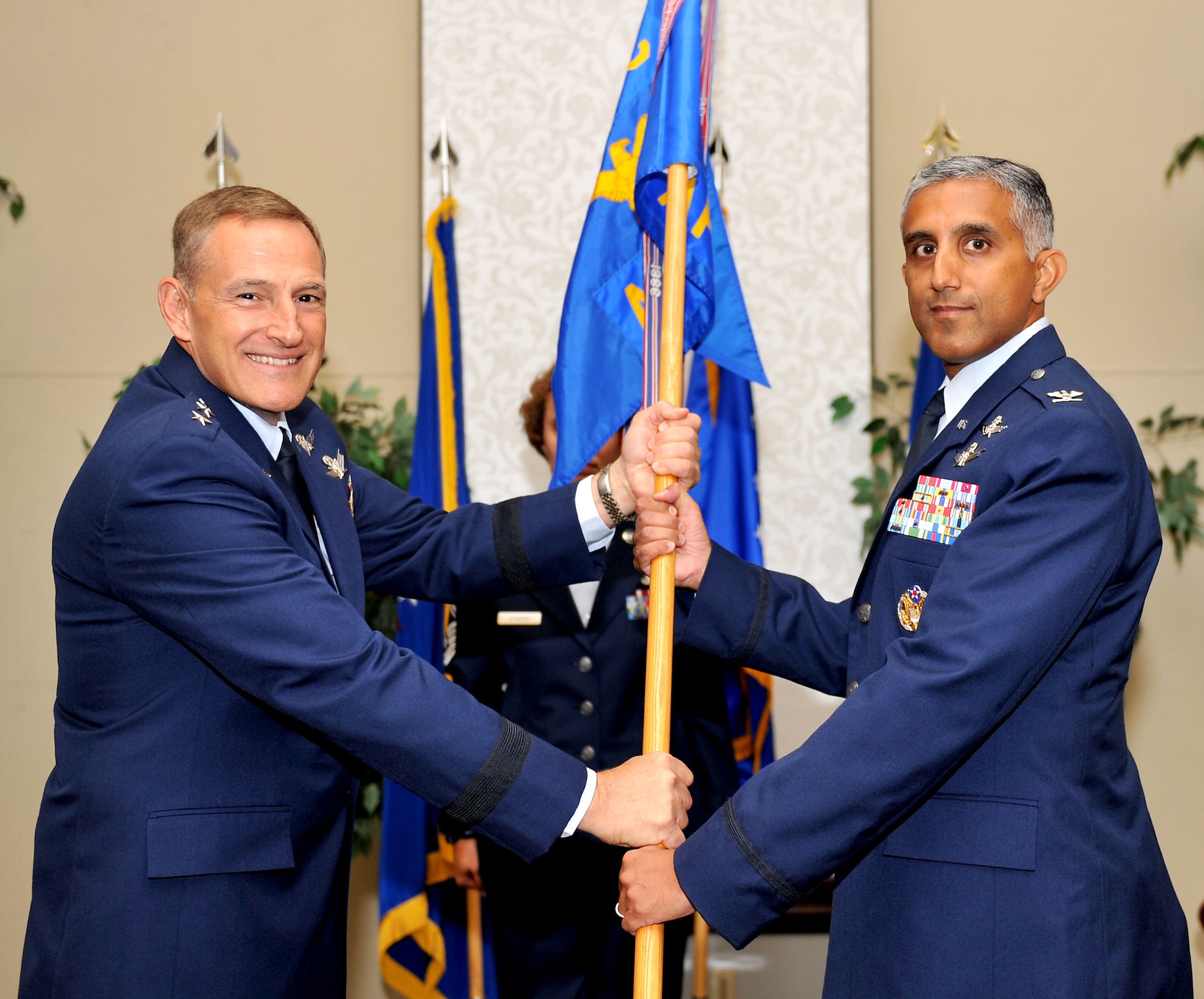 SCOTT AIR FORCE BASE, Ill. -- Lt. Gen. Michael Basla, vice commander of Air Force Space Command, presents the Air Force Network Integration Center guidon to its new commander, Col. Rizwan “Riz” Ali, during a change of command ceremony Aug. 3.  AFNIC is the Air Force’s technical center of excellence for Air Force network integration.   (U.S. Air Force photo/ Airman 1st Class Divine Cox)