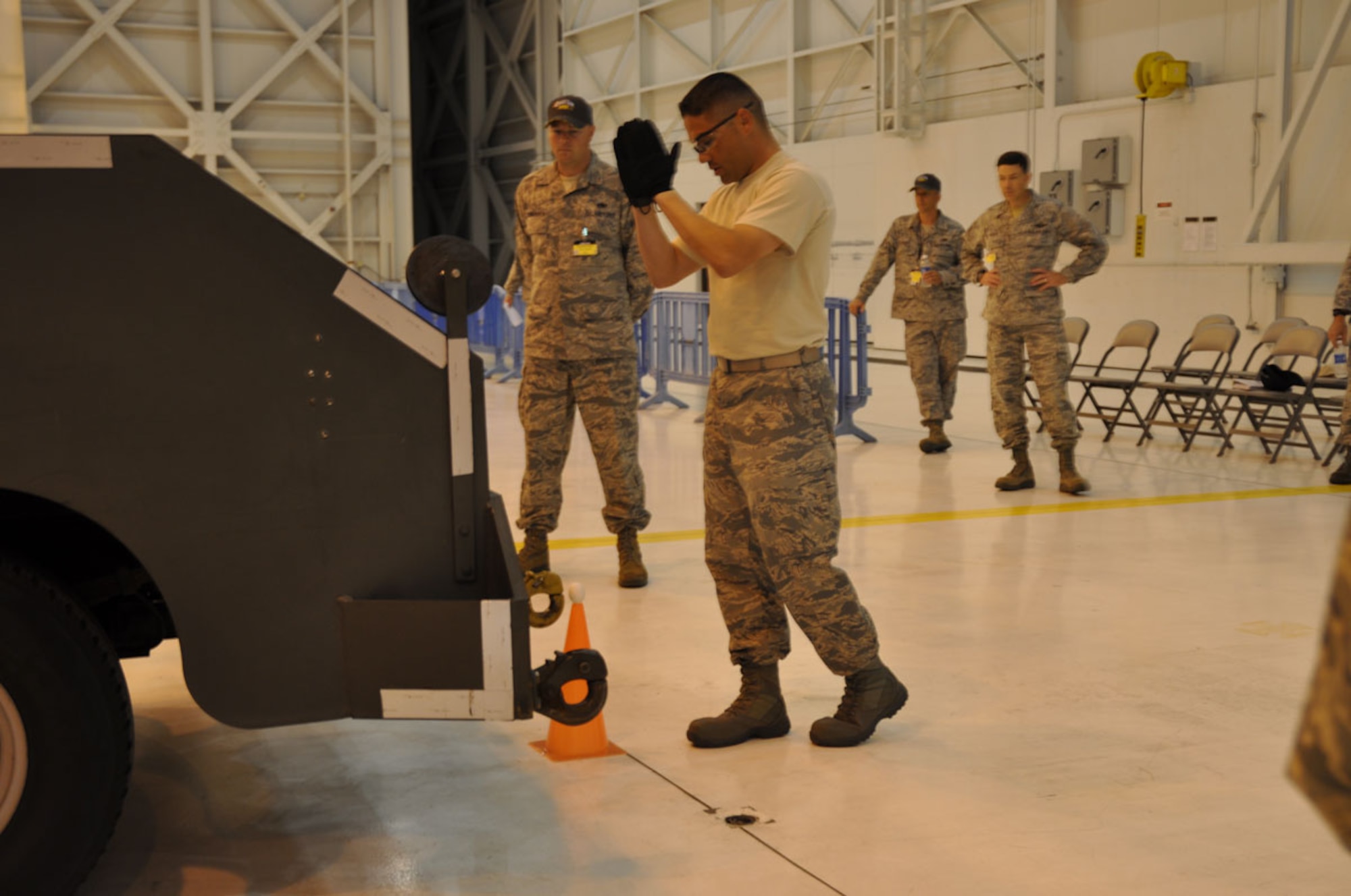 Tech. Sgt Carlos Obregon, 703d Aircraft Maintenance Squadron Electrician and Environmental Craftsman and Team Alaska participant, directs the vehicle as close to the cone as possible without breaking the egg during the Maintenance Skills Event at the 2011 AMC Rodeo on 25 July. (U.S. Air Force photo/Capt. Corinna Jones)