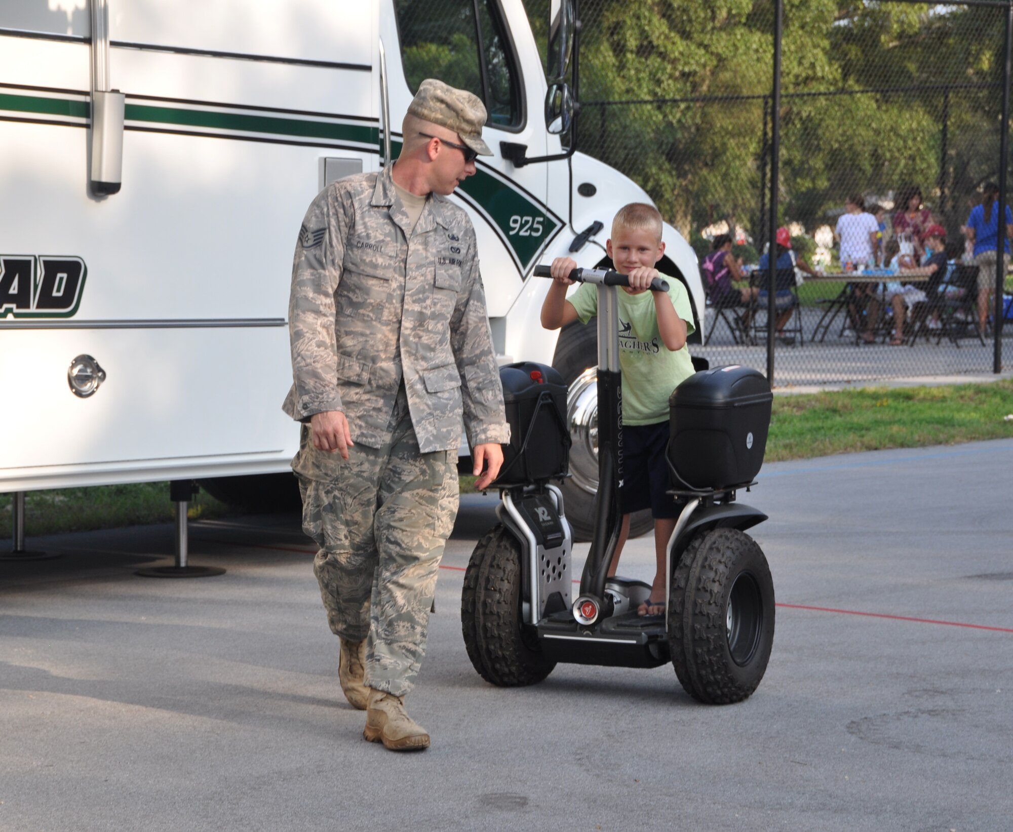 Staff Sgt. Aaron Carroll, 325th Civil Engineer Squadron, teaches 8-year-old Jordan Rienzo to ride on a Segway Aug. 2 during Tyndall’s National Night Out event. Balfour Beatty Communities, Tyndall Community Police and Base Partners held the event to raise awareness about crime prevention at Tyndall.  (U.S. Air Force photo by Senior Airman Veronica McMahon)