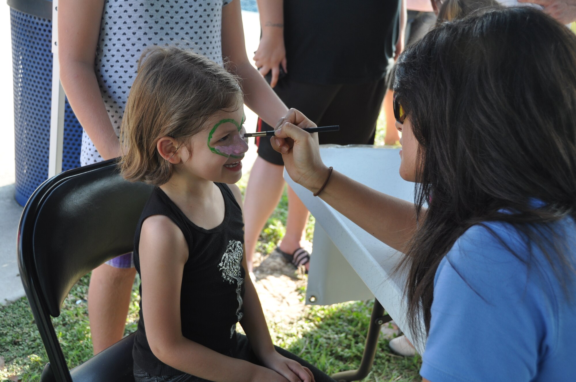 Balfour Beatty employee Alyssa Holmes paints the face of 5-year-old Journey Callais Aug. 2 during Tyndall’s National Night Out event.  Balfour Beatty Communities, Tyndall Community Police and Base Partners held the event to raise awareness about crime prevention at Tyndall.  (U.S. Air Force photo by Senior Airman Veronica McMahon)