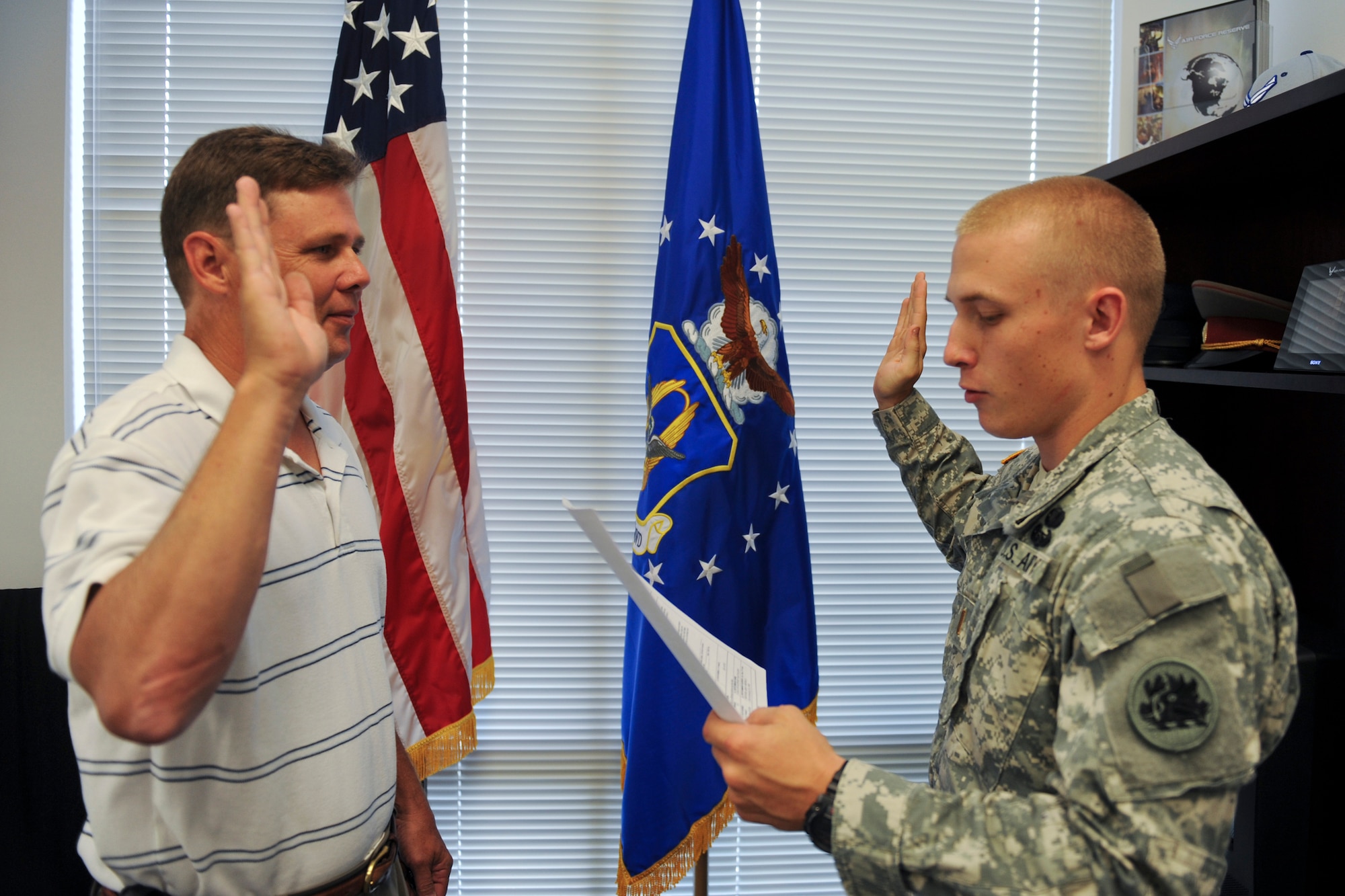 Scott Long recites the Oath of Enlistment after his son, U.S. Army 2nd Lt. Brandon Long, during a ceremony July 28, 2011, in Valdosta, Ga. Lieutenant Long is a liaison officer with the 1-169 Aviation Support Battalion and said he was honored to preside over his father’s ceremony since his father pinned on his officer rank earlier this year. (U.S. Air Force photo by Staff Sgt. Jamal D. Sutter/Released)