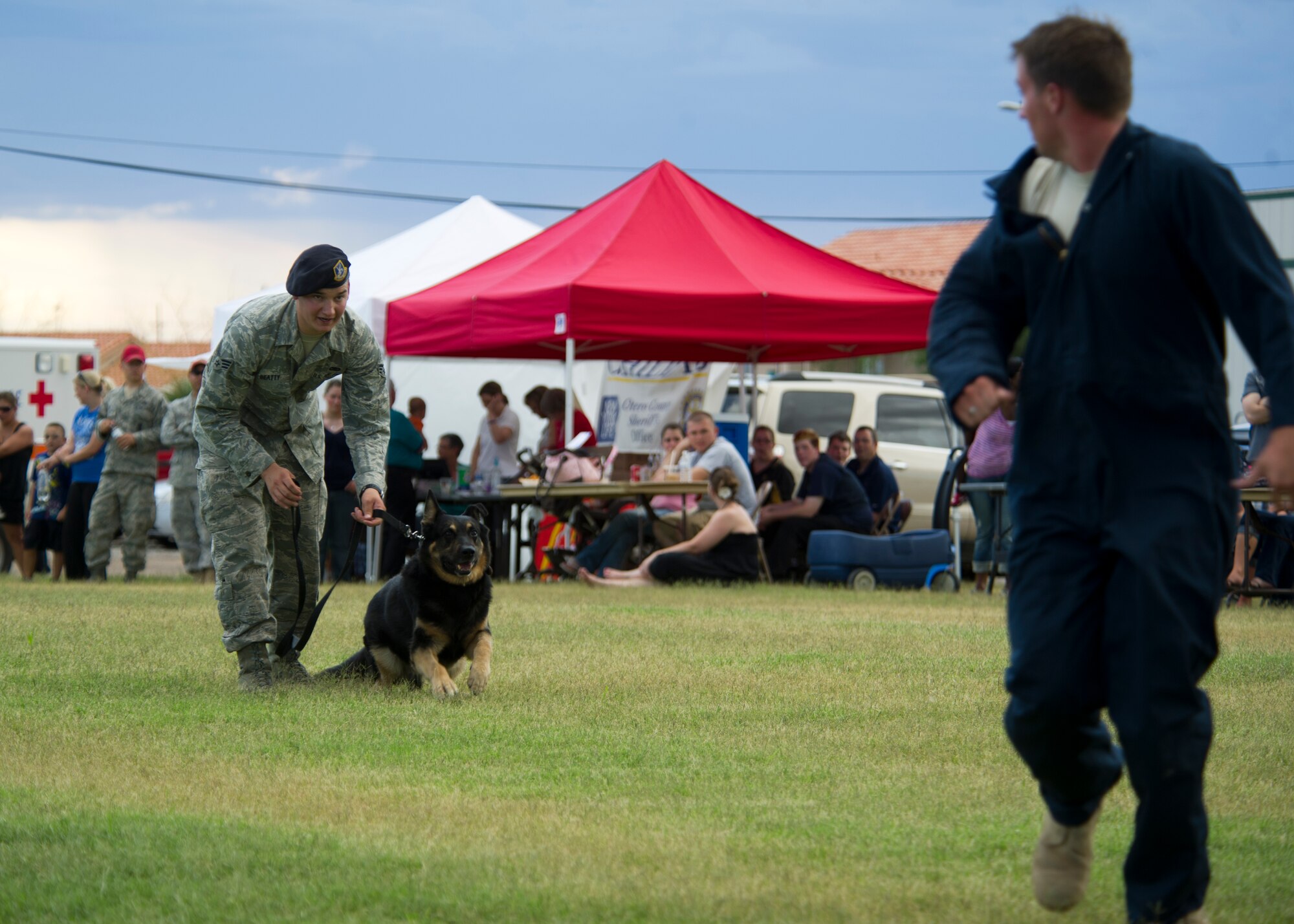 HOLLOMAN AIR FORCE BASE, N.M. -- Ate, a military working dog, chases U.S. Air Force Staff Sgt. Joel Munson, 49th Security Forces Squadron kennel trainer, during an attack scenario, Aug. 2, 2011, at the “National Night Out” event hosted by Soaring Heights. As a way of letting the neighborhood see how the base is kept safe, the 49th SFS also performed a combat defense tactic with a Gladiator suit. (U.S. Air Force photo by Senior Airman Veronica Stamps/Released)