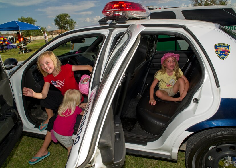 HOLLOMAN AIR FORCE BASE, N.M. -- Lily and Olivia Huston and Taylor Bankhead, daughters of U.S. Air Force Tech. Sgt. Molly Huston, 44th Maintenance Group, take a look inside a police car, Aug. 2, 2011, during the “National Night Out” event hosted by Soaring Heights. Outside agencies such as the United States Customs and Border Protection, Alamogordo Police Department and Otero County Fire Department attended the event to showcase their support in the fight for a safer community. (U.S. Air Force photo by Senior Airman Veronica Stamps/Released) 