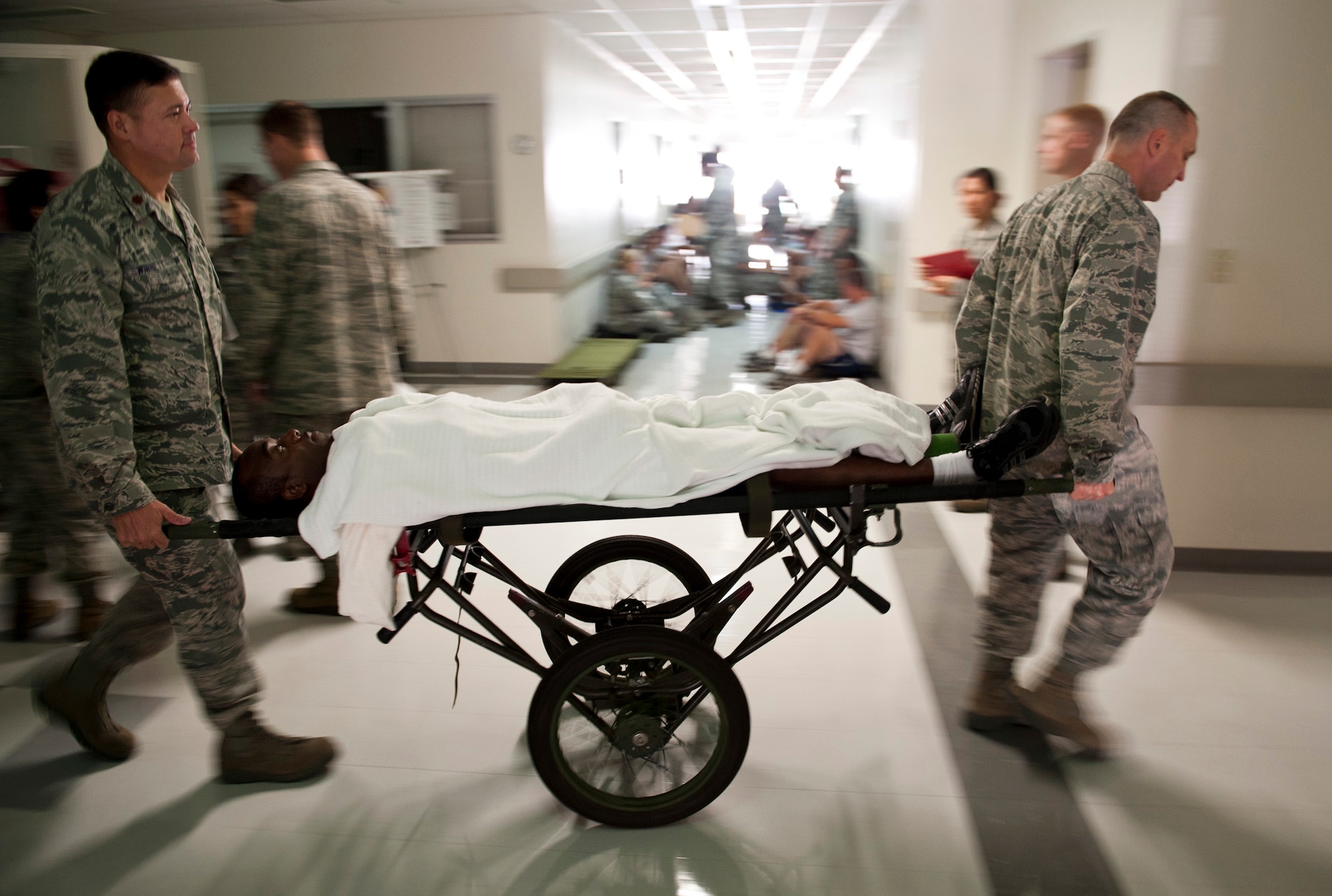 YOKOTA AIR BASE, Japan -- Maj. Stephen Winnett (left), 374th Aerospace Medicine Squadron, and Maj. Aaron Dimitras (right), 374th Medical Surgical Squadron, transport a simulated patient down the hall during an emergency management exercise at Yokota Air Base, Japan, Aug. 4, 2011. The exercise gave Yokota' emergency responders a chance to practice managing the various complexities of mass casualty scenario. (U.S. Air Force photo/Staff Sgt. Samuel Morse)