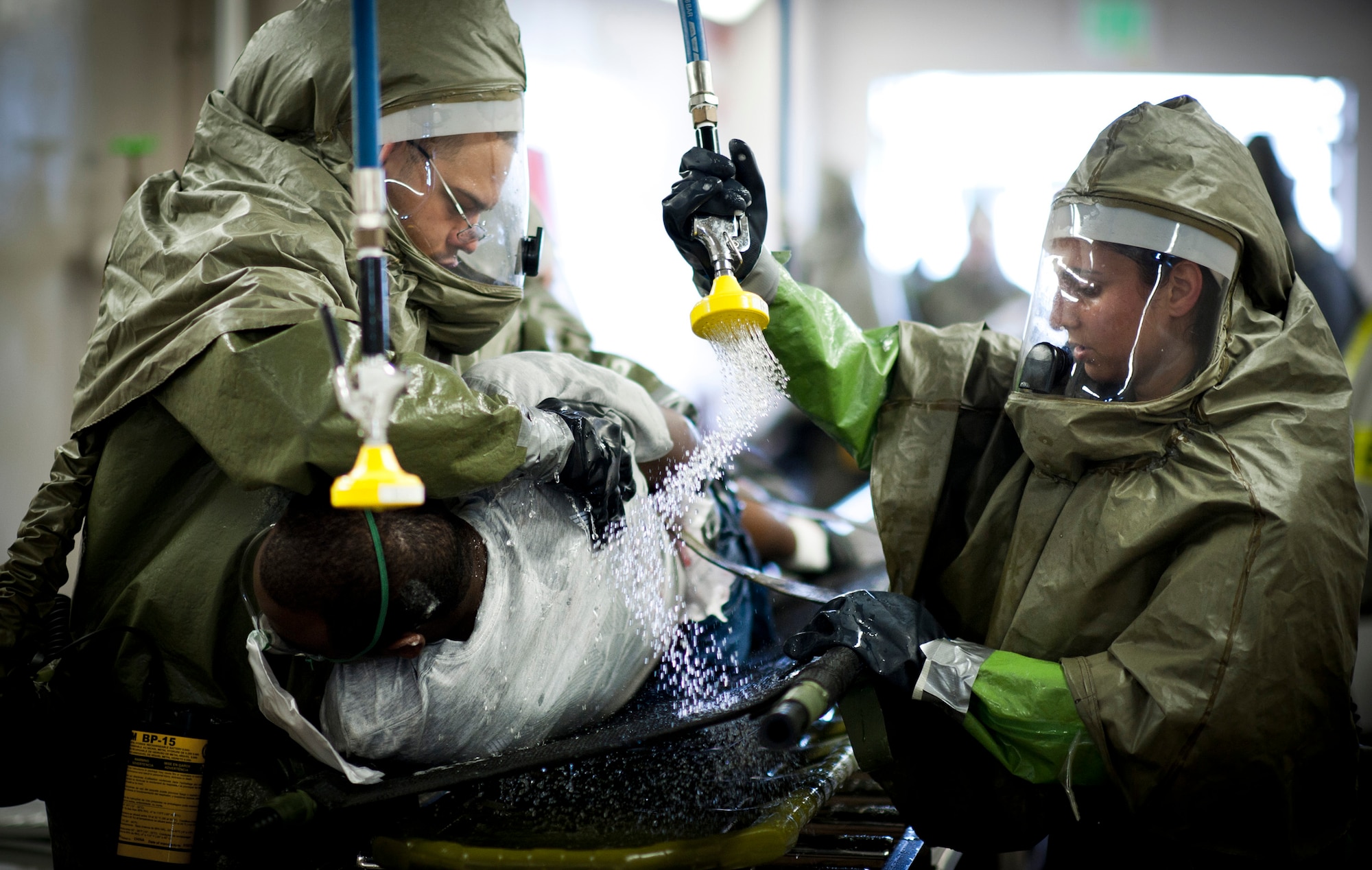 YOKOTA AIR BASE, Japan -- Capt Malisha Martukovich (right), 374th Aerospace Medicine Squadron audiologist, practices decontamination procedures by spraying a simulated victim with water at Yokota Air Base, Japan, during a emergency management exercise July 4, 2011. The exercise scenario centered around a simulated ?dirty bomb? explosion at the base fitness center. (U.S. Air Force photo/Staff Sgt. Samuel Morse)