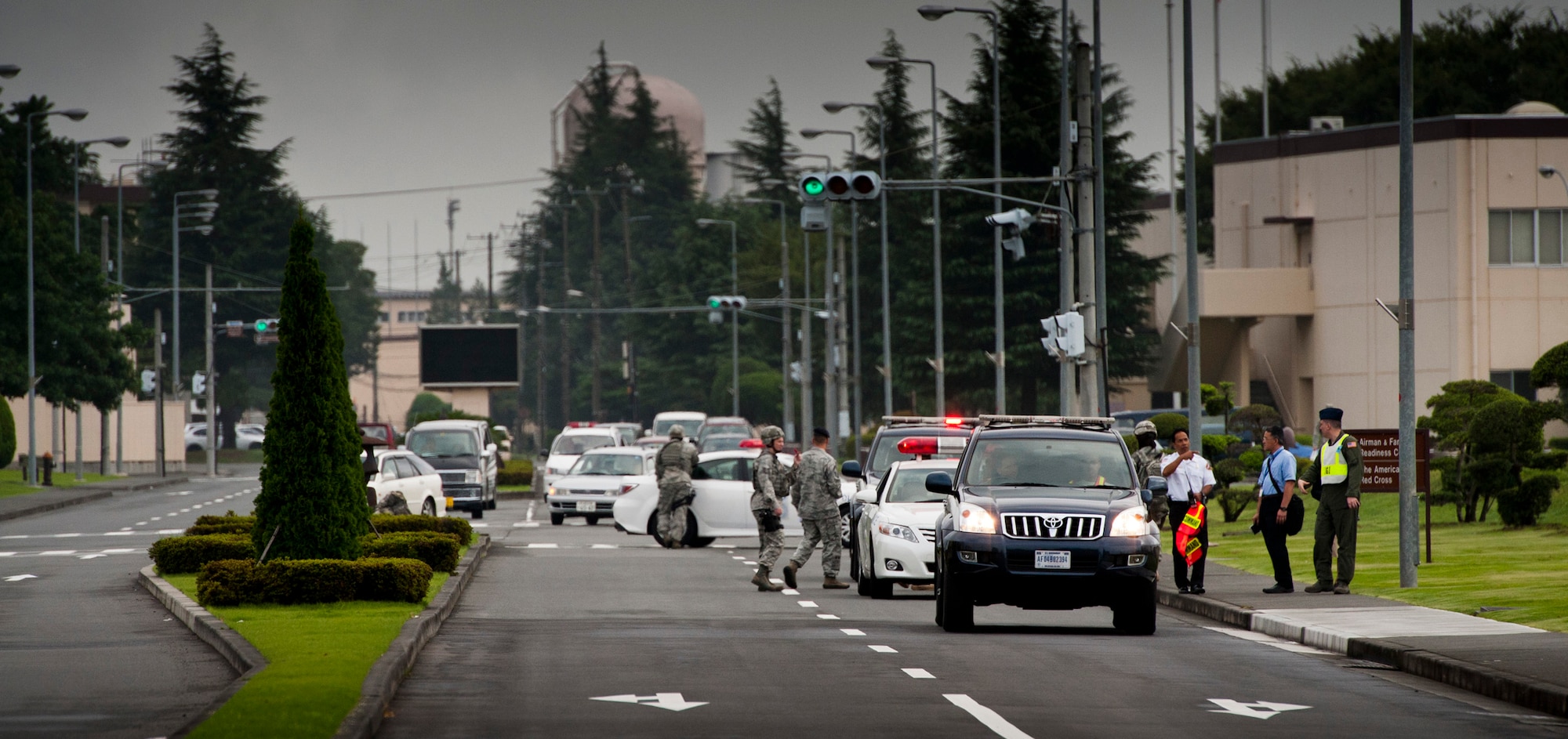 YOKOTA AIR BASE, Japan -- Members of the 374th Security Forces Squadron set up a roadblock on Airlift Avenue during an emergency management exercise at Yokota Air Base, Japan, Aug. 4, 2011. The scenario included a simulated explosion at the Samurai Fitness Center, prompting the security forces personnel to set up road blocks and a perimeter to keep bystanders safe from potential hazards and protect their simulated casualty collection point from traffic. (U.S. Air Force photo/Staff Sgt. Samuel Morse)