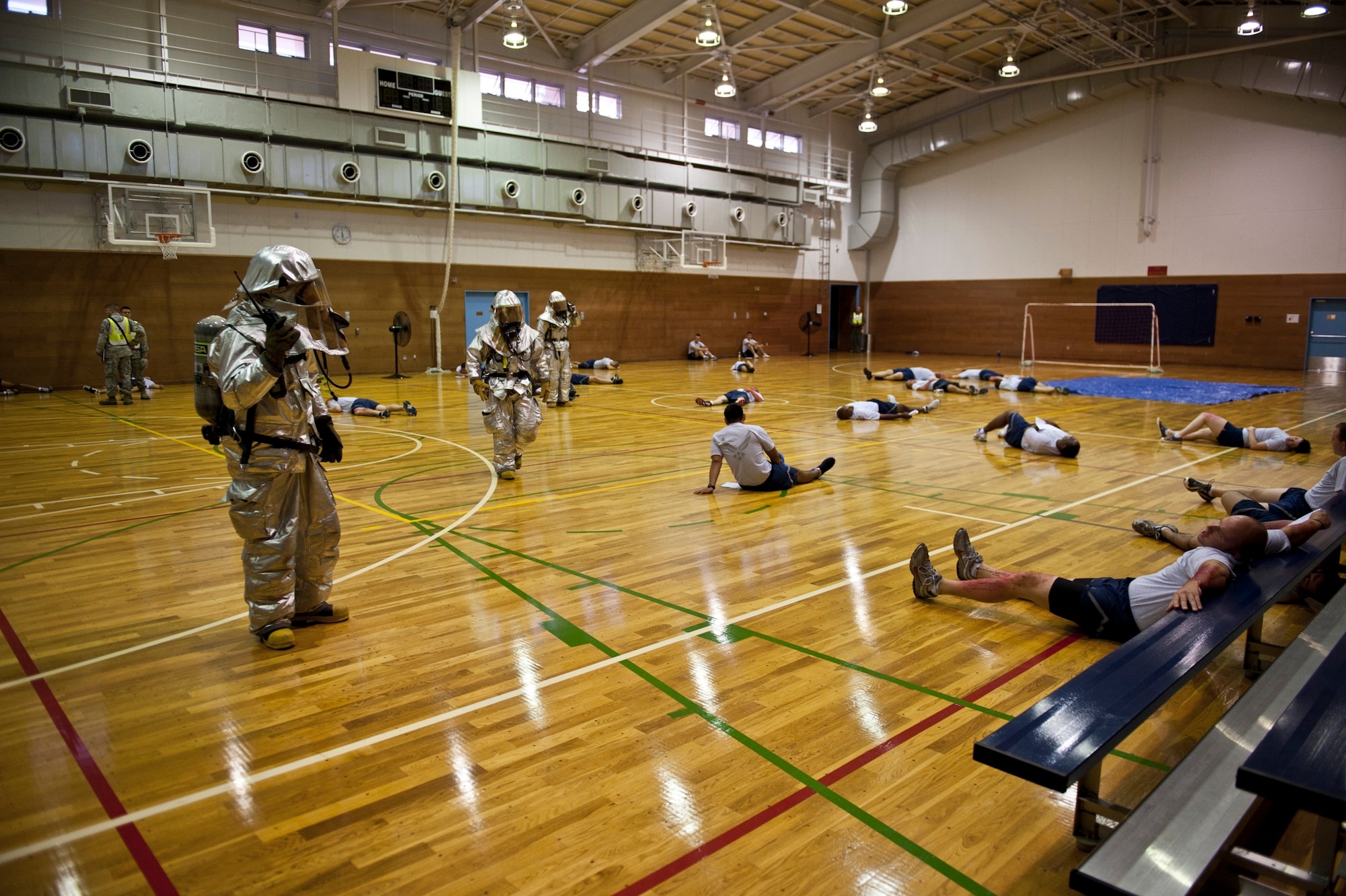 YOKOTA AIR BASE, Japan -- Firefighters with the 374th Civil Engineer Squadron survey the scene of a simulated mass casualty incident at the Samurai Fitness Center, Yokota Air Base, Japan, during an emergency management exercise Aug. 4, 2011. The simulated scenario was a "dirty bomb" explosion in the basketball court. (U.S. Air Force photo/Staff Sgt. Samuel Morse)
