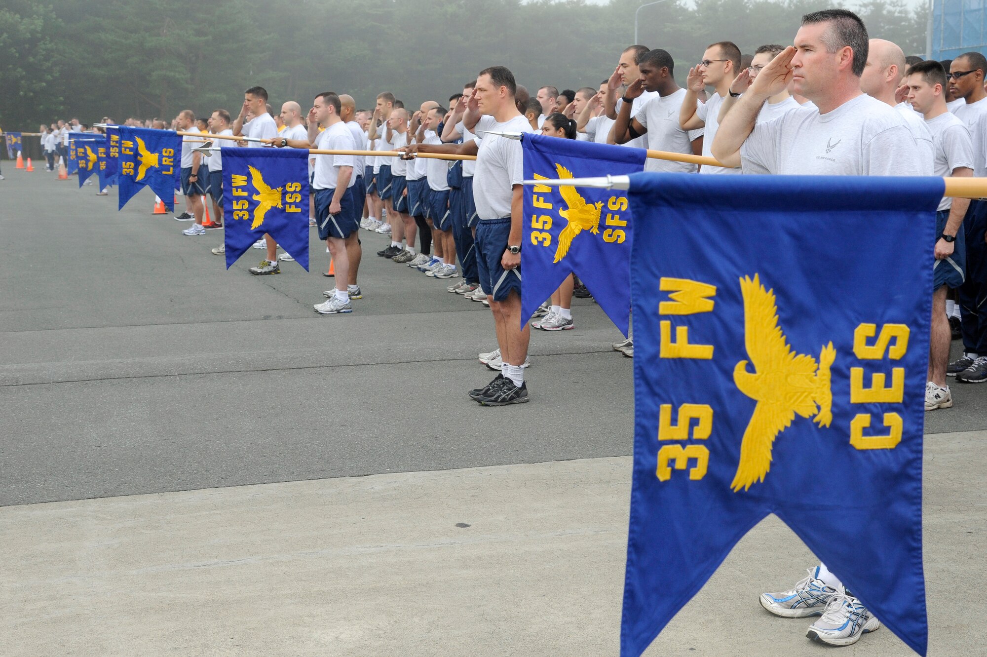 MISAWA AIR BASE, Japan -- Airmen from the 35th Fighter Wing salute during the playing of the National Anthems prior to the start of Augusts readiness run Aug. 5th. Readiness runs are held the first Friday of every month to promote health and fitness throughout the base. (U.S. Air Force photo/Staff Sgt. Marie Brown)