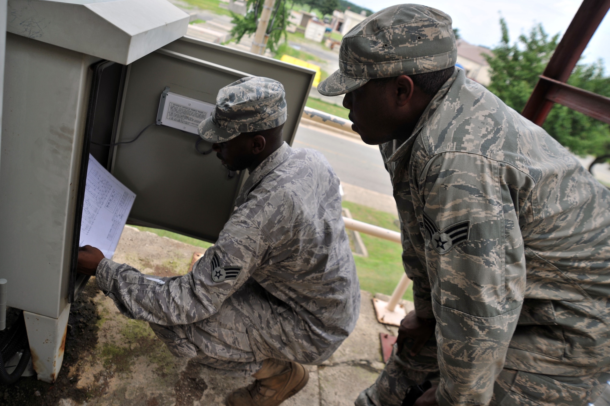 KUNSAN AIR BASE, Republic of Korea -- Senior Airman Edgar Denard and SrA Myron Gordan, 8th Civil Engineer Squadron heating, ventilating, air conditioning and refrigerating technicians adjust system controls here Aug. 4. HVAC Airmen maintain 1.7K HVAC/R Systems base-wide and assist the Army with specialized air conditioning equipment. (U.S. Air Force photo/Senior Airman Brittany Y. Bateman)