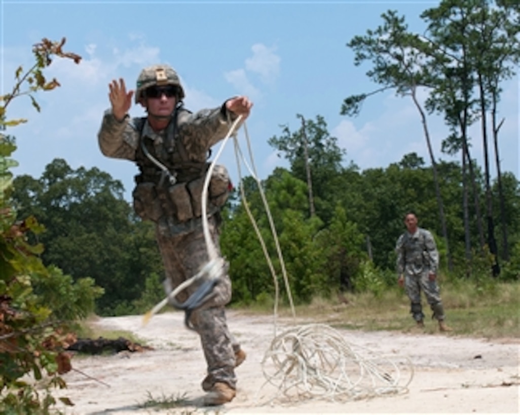 A U.S. Army soldier throws a grappling hook to clear a potential mine field before advancing during a field training exercise at Fort Bragg, N.C., on July 21, 2011.  The soldier is with the 1st Brigade Combat Team, 82nd Airborne Division.  