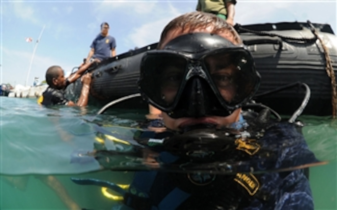 U.S. Navy Petty Officer 2nd Class Justin McMillen, assigned to Mobile Diving and Salvage Unit 2, surfaces after a dive with a member of the Jamaican Coast Guard in support of Navy Diver-Southern Partnership Station off Port Royal, Jamaica, on July 22, 2011.  Southern Partnership Station is an annual deployment of U.S. ships to the U.S. Southern Command's area of responsibility in the Caribbean and Latin America.  The exercise involves information sharing with navies, coast guards and civilian services throughout the region.  