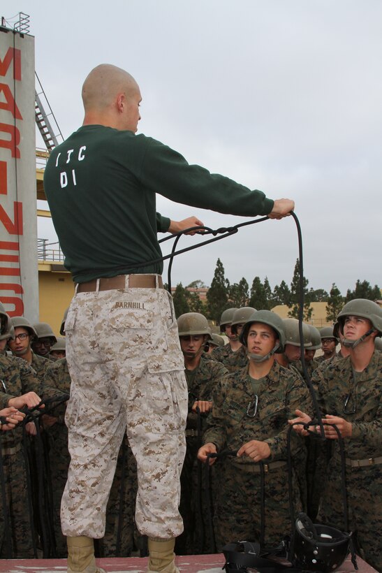 Company C recruits watch as Sgt. James Barnhill an Instructional Training Company drill instructor shows them how to make their harness out of a length of rope Aug. 5. They were to follow the directions meticulously to make sure their harness was tight enough to hold them.