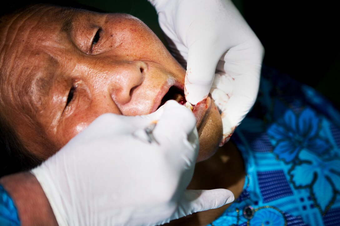 An elderly Mongolian woman waits patiently as a Lt. Col. Jim Arneson, a dentist with the Alaska Army National Guard, removes her tooth during the Medical and Dental Civic Action Program of Exercise Khaan Quest 2011 in Ulaanbaatar, Mongolia, Aug. 7. Medical personnel from Mongolia, Canada, India, Korea and the U.S. shared their expertise to provide medical and dental care for hundreds of Mongolian citizens daily. Khaan Quest is a training exercise designed to strengthen the capabilities of U.S., Mongolian and other participating nations’ forces in international peace support operations worldwide.
