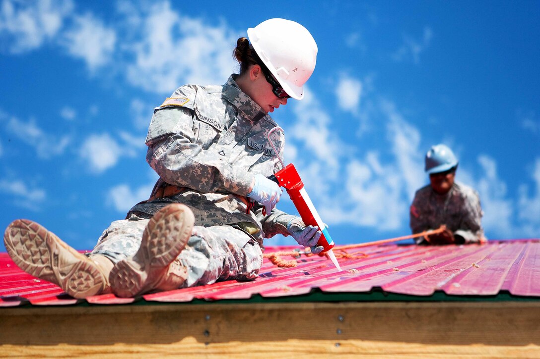 Army Pfc. Danielle Robinson, a carpenter and mason with the 84th Battalion, 30th Brigade, 643rd Company out of Schofield Barracks, Hawaii, seals gaps in sheet metal roofing during the Engineering Civic Action Program portion of Exercise Khaan Quest 2011 in Ulaanbaatar, Mongolia, Aug. 1. The purpose of the program is to improve medical care in the area by adding on to the Ayut Family Hospital, a 17,000 square foot urgent care clinic, which will serve the 9th sub-district of khaan-Uul District. Khaan Quest is a training exercise designed to strengthen the capabilities of U.S., Mongolian and other participating nations’ forces in international peace support operations and civic outreach programs worldwide.