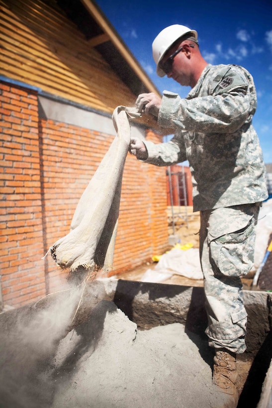 A soldier with 84th Battalion, 30th Brigade, 643rd Company from Schofield Barracks, Hawaii, empties a bag of cement that will be mixed into brick mortar during the Engineering Civic Action Program portion of Exercise Khaan Quest 2011 in Ulaanbaatar, Mongolia, Aug. 1. The purpose of the program is to improve medical care in the area by adding on to the Ayut Family Hospital, a 17,000 sq. ft. urgent care clinic, which will serve the 9th sub-district of khaan-Uul District. Khaan Quest is a training exercise designed to strengthen the capabilities of U.S., Mongolian and other participating nations’ forces in international peace support operations and civic outreach programs worldwide.