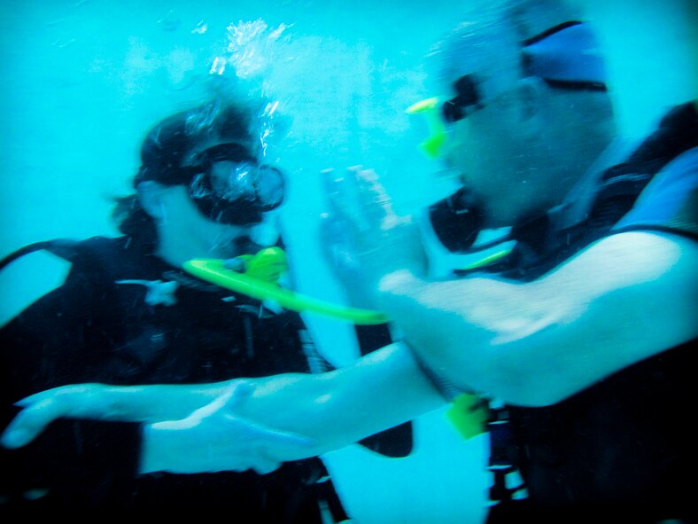 WAITING TO INHALE - Using hand signals to communicate under water, the divers first attempted to spot their group, and then decided to surface. But their inexperience caused them to not account for the weight of their equipment and the water currents, which were pulling them deeper and deeper into the bay. (Photo by TSgt Samuel Bendet)