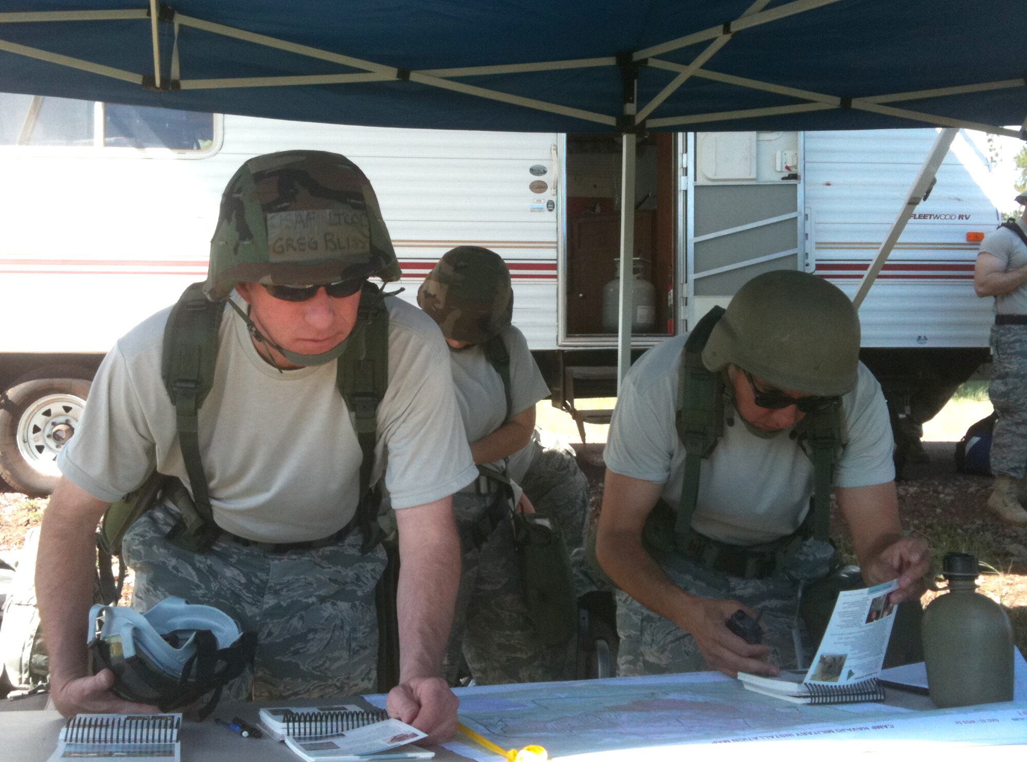 Lt. Col. Greg Bliss and Chief Master Sgt. Armando Gonzales review the Airman’s Manual for force protection condition procedures. (U.S. Air Force photo/Lt. Col. Garry Beauregard)